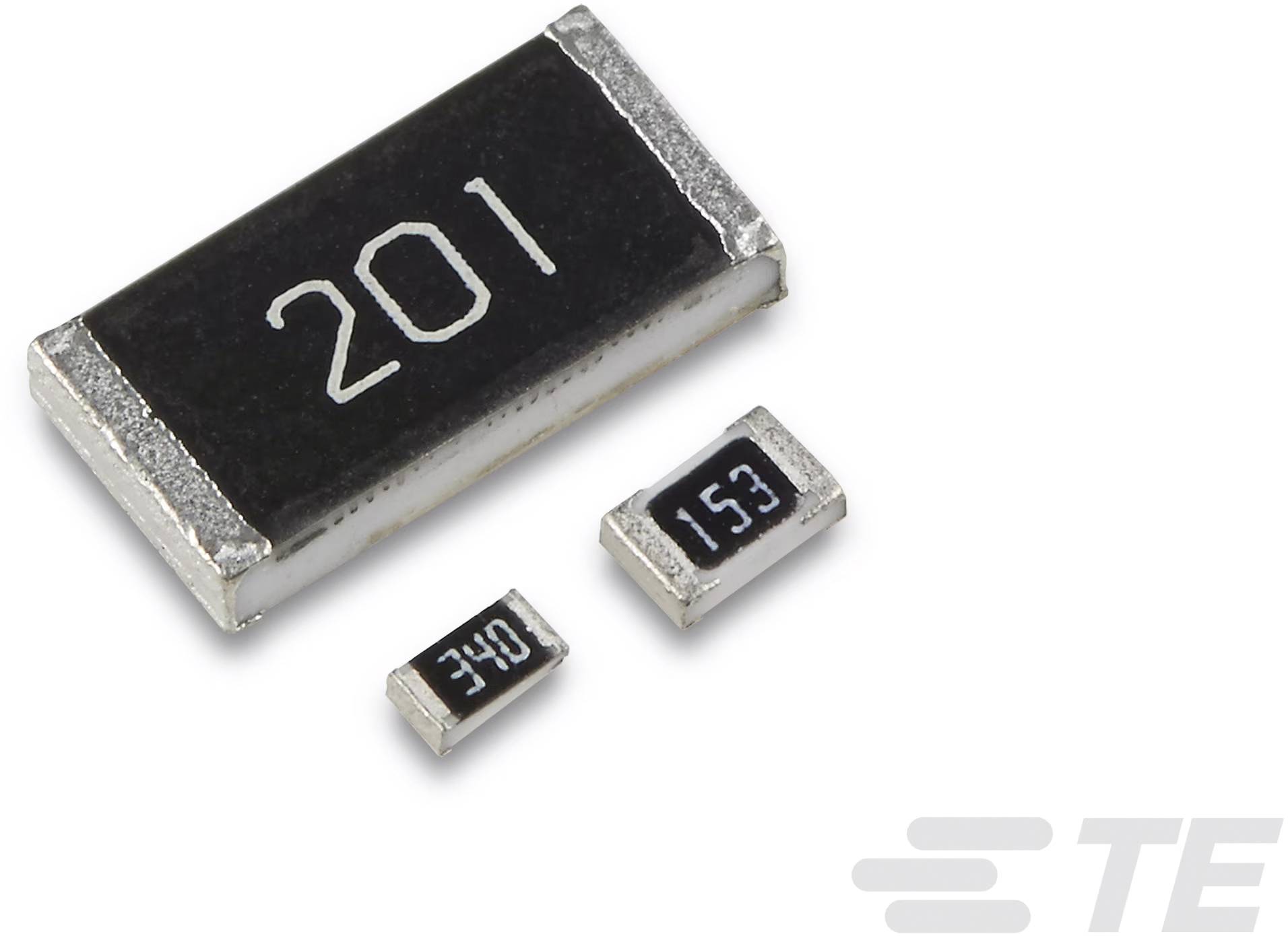 Három különböző méretű SMD-ellenállás '201', '340' és '153' jelöléssel egy fehér felületen.