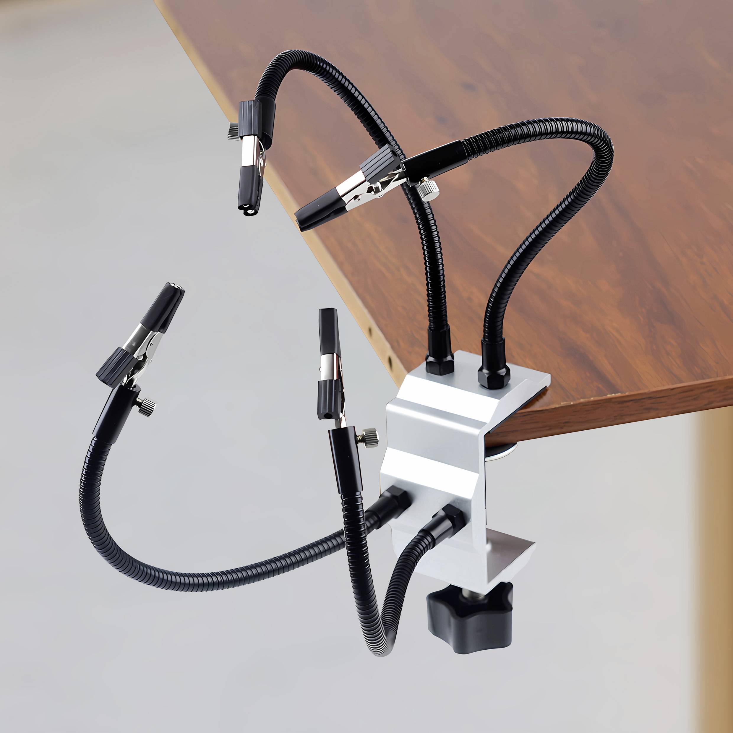 Négy rugalmas tartó bilinccsel van rögzítve az asztal széléhez, különböző szerszámok vagy tartozékok elhelyezésére alkalmas.