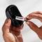 Egy személy egy 'Energizer' elemet helyez egy fekete eszközbe. Az eszköz lehet egy távirányító vagy egy egér.