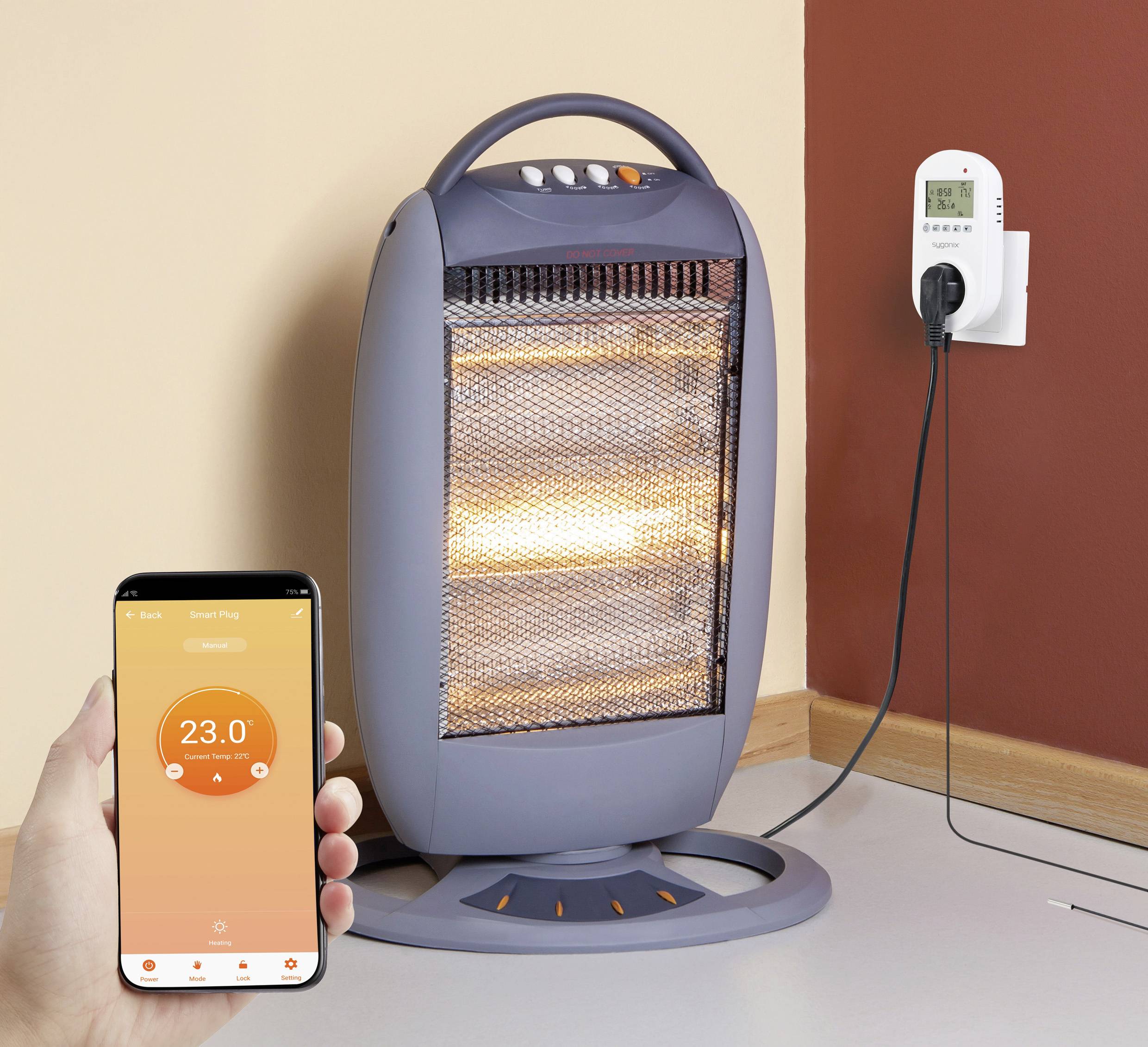 Egy elektromos fűtőberendezés áll a sarokban. Egy kéz okostelefont tart, amely 23,0 fokos hőmérsékletet mutat egy alkalmazásban.