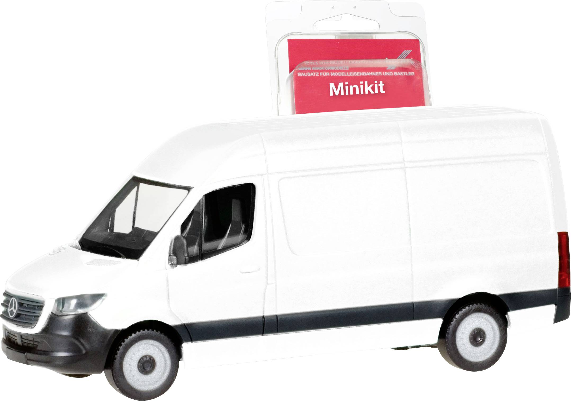 Egy fehér kisteherautó modell egy 'Minikit' feliratú csomagolás előtt.