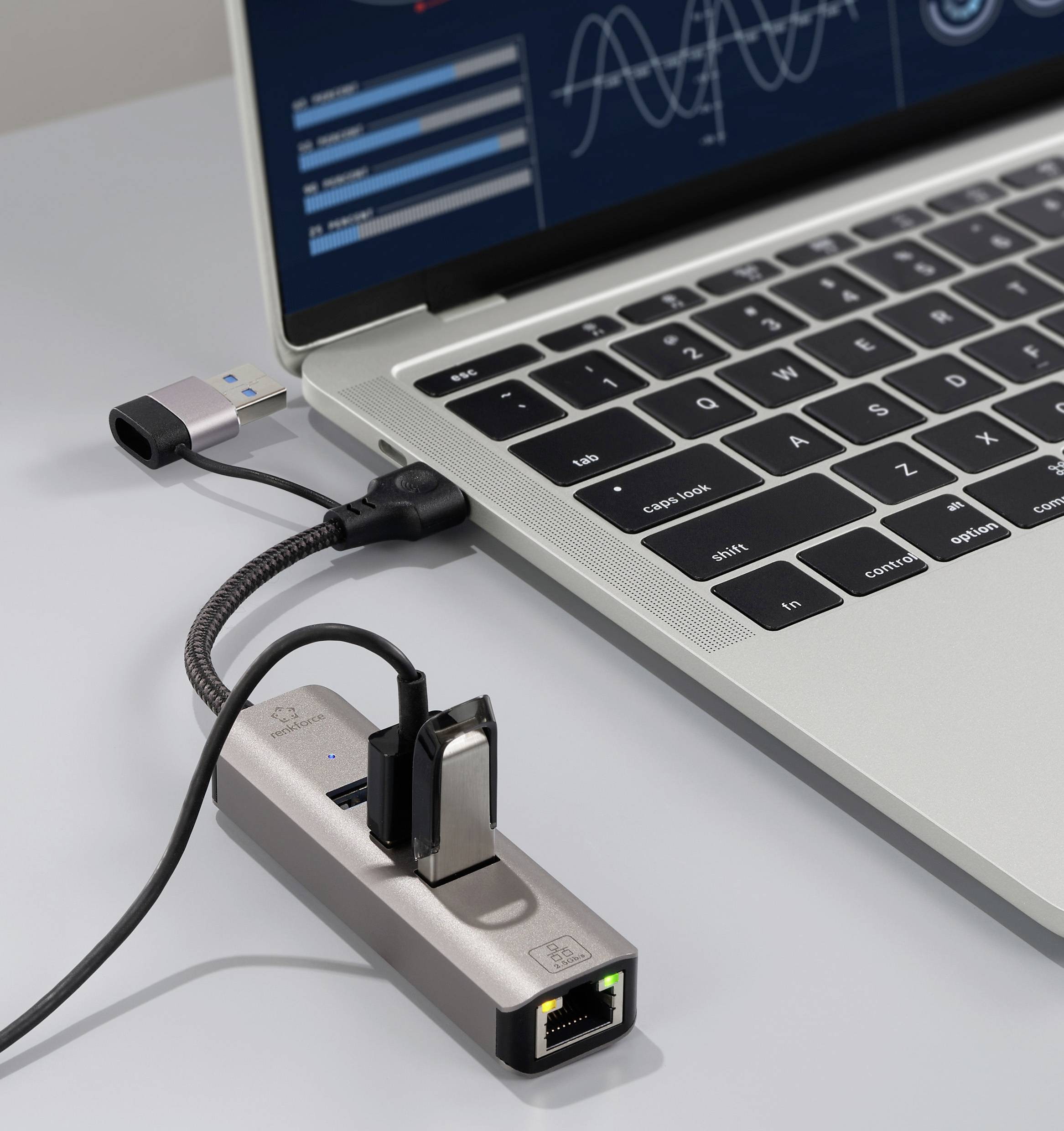 Egy laptop USB hub-bal csatlakoztatva, különböző portokkal, köztük Ethernet és USB portokkal, amely a kapcsolódási és bővítési lehetőségeket szemlélteti.