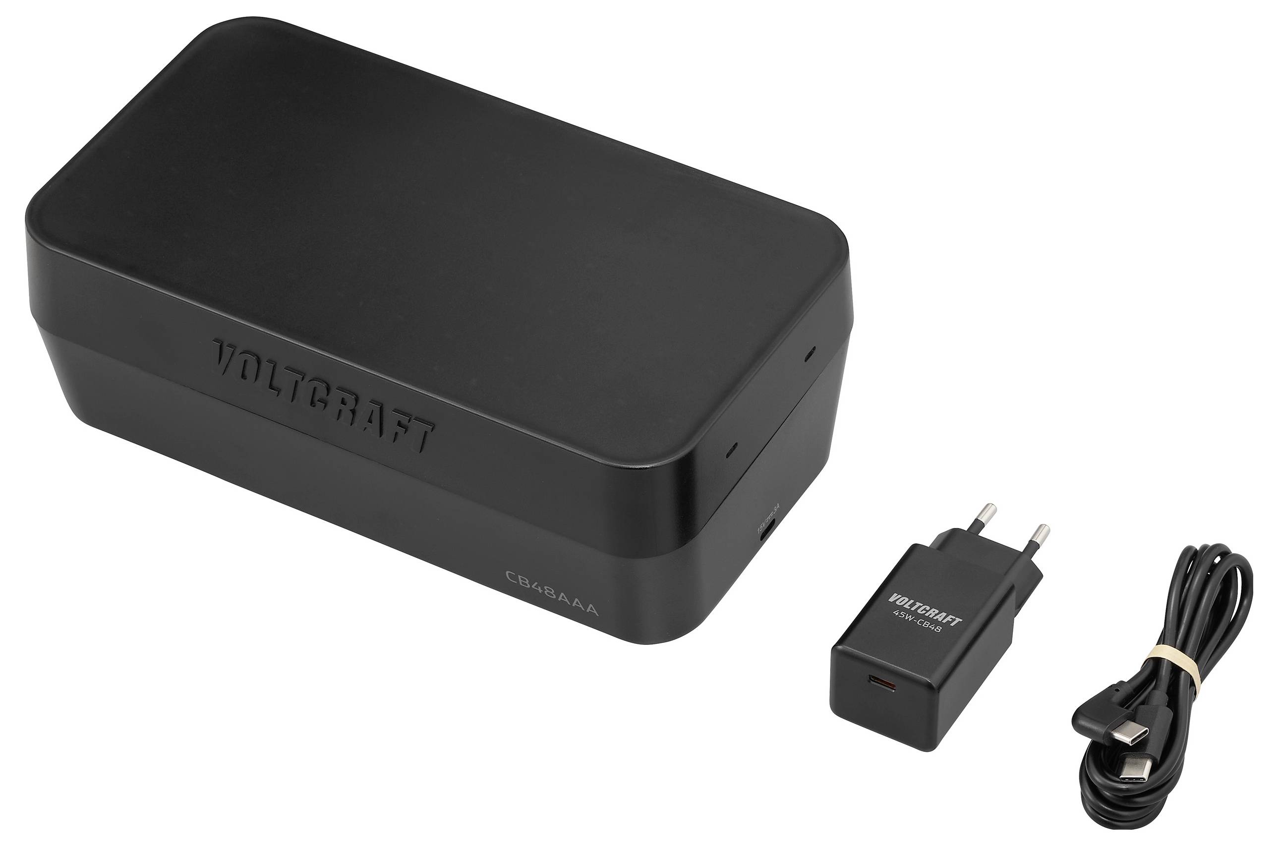 'Voltcraft' fekete power bank szett, amely tartalmaz egy téglalap alakú power bankot, egy AC adaptert és egy USB kábelt.