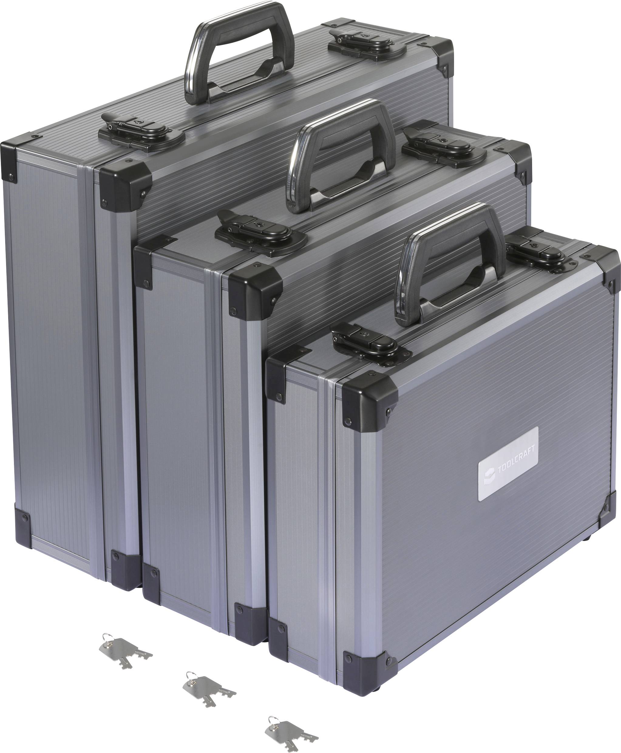 Három különböző méretű ezüstszínű fémdoboz van egymásra pakolva, mindegyiknek fekete fogantyúja és sarokvédője. Három kulcs van a dobozok alatt.