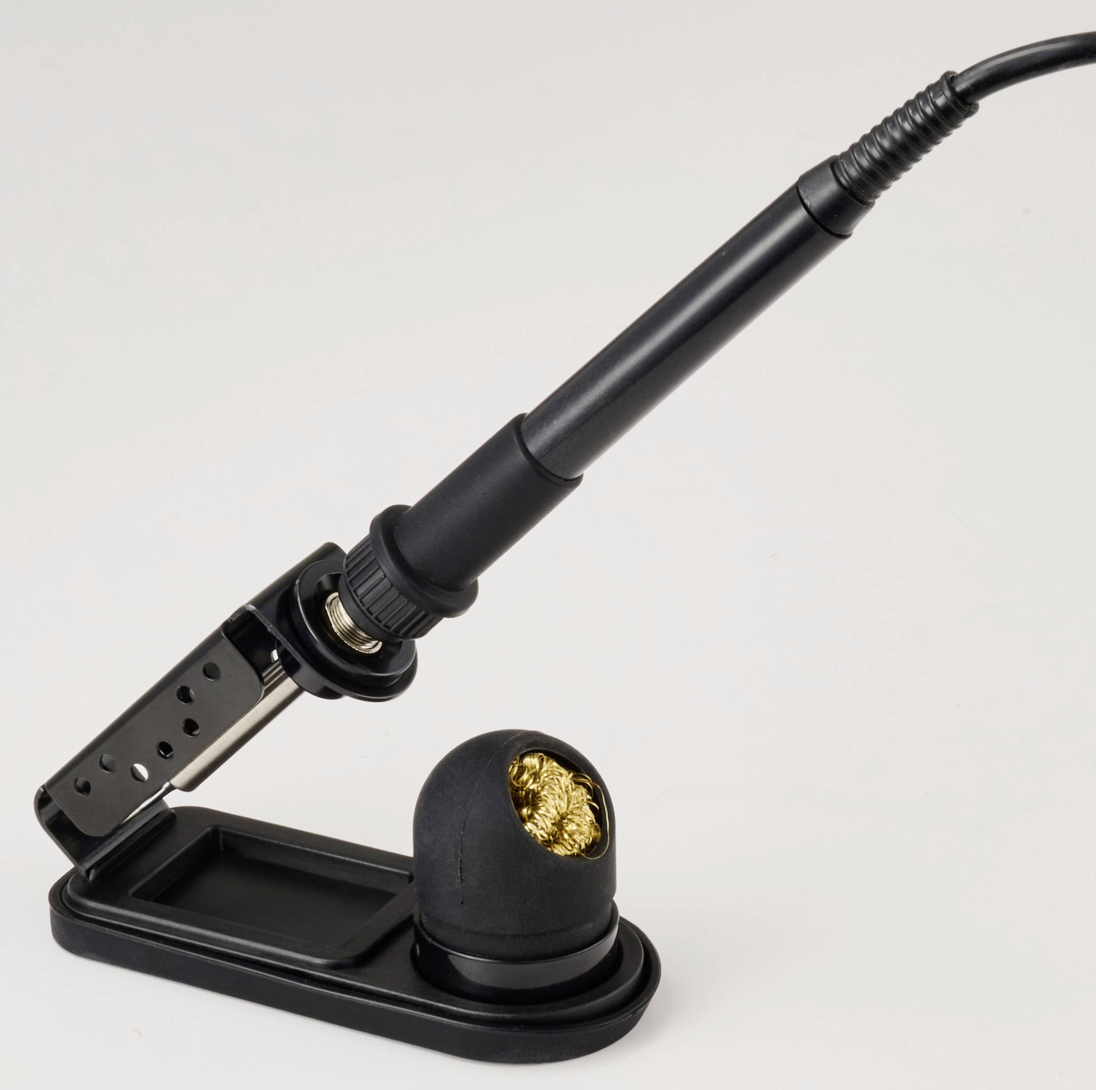 Egy fekete forrasztópáka egy tartóban, amelyben egy csavart réz szivacs található a hegy tisztítására, sima háttér előtt.