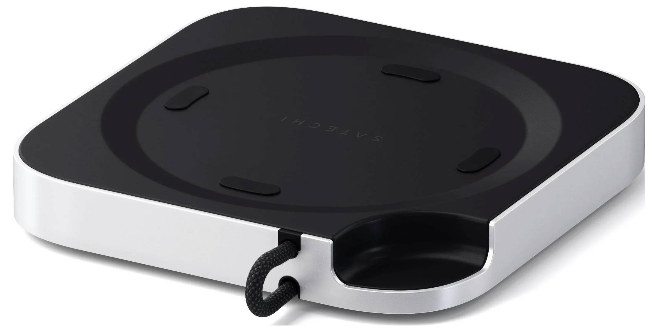 Egy karcsú, négyzet alakú fekete vezeték nélküli töltőpad fémes szegéllyel, kábelvezető horonnyal és minimalista dizájnnal.