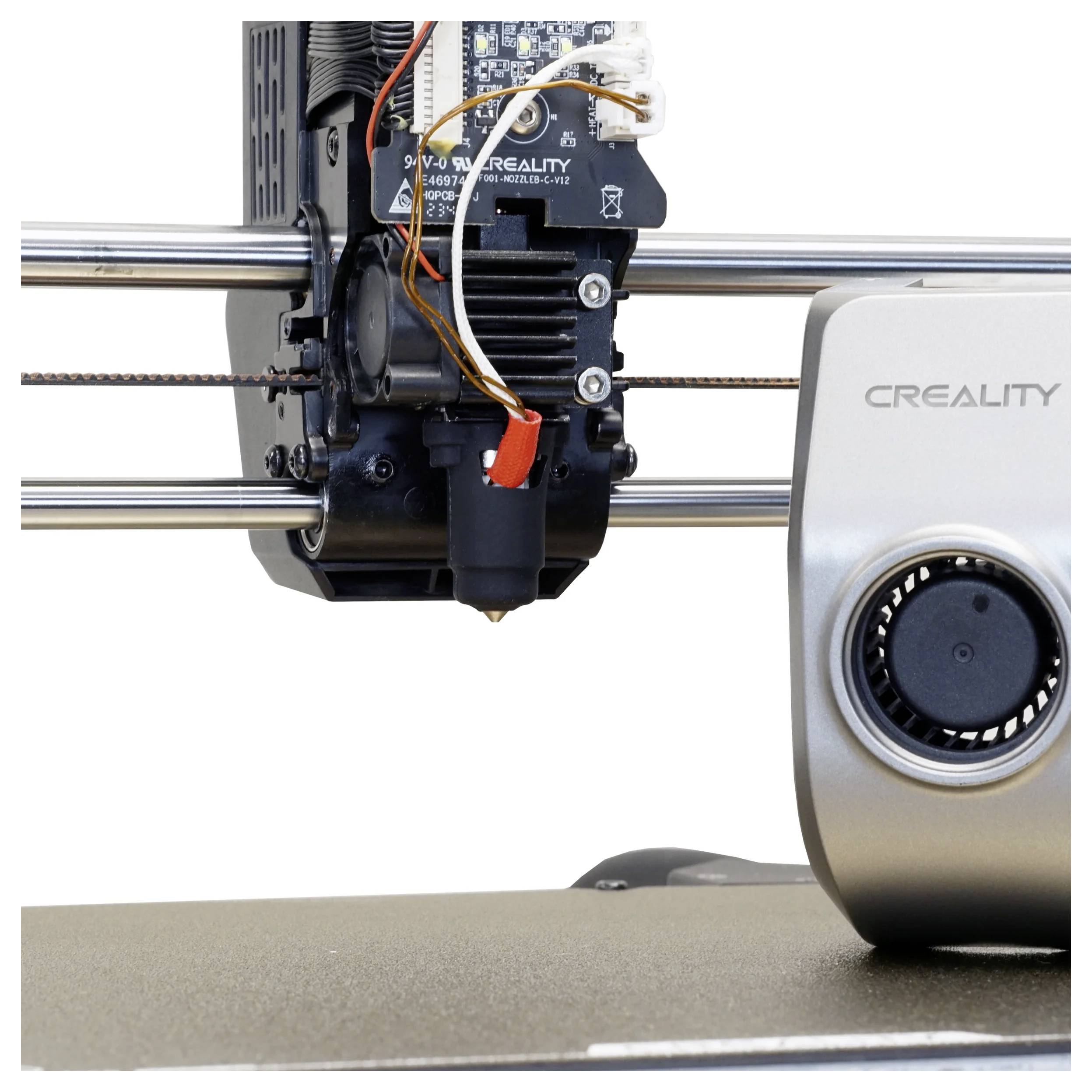 Egy 3D-nyomtató fúvókája és extrudere működés közben, fémrudakra szerelve. A nyomtató ventilátor fedelén a Creality márkanév látható.