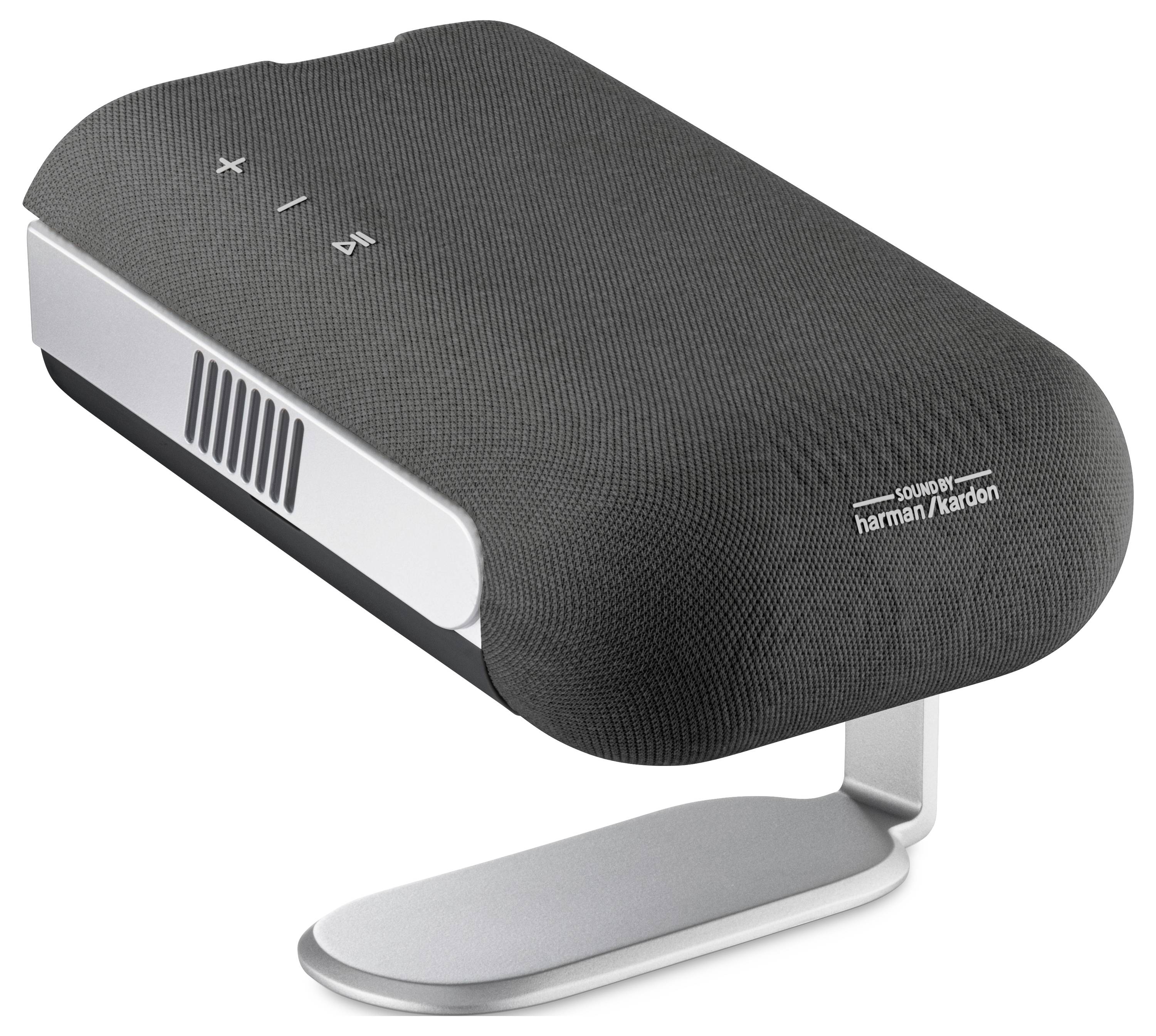 Egy karcsú, modern Harman/Kardon vezeték nélküli hangszóró fekete színben, érintésvezérlésű gombokkal a tetején, egy fémállványon hang lejátszására tervezve.