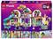 Lego Friends játékszett élénk, színes épületekkel és karakterekkel, akik különböző szórakoztató tevékenységeket végeznek, beleértve egy csúszdát és egy nyúlfigurát.