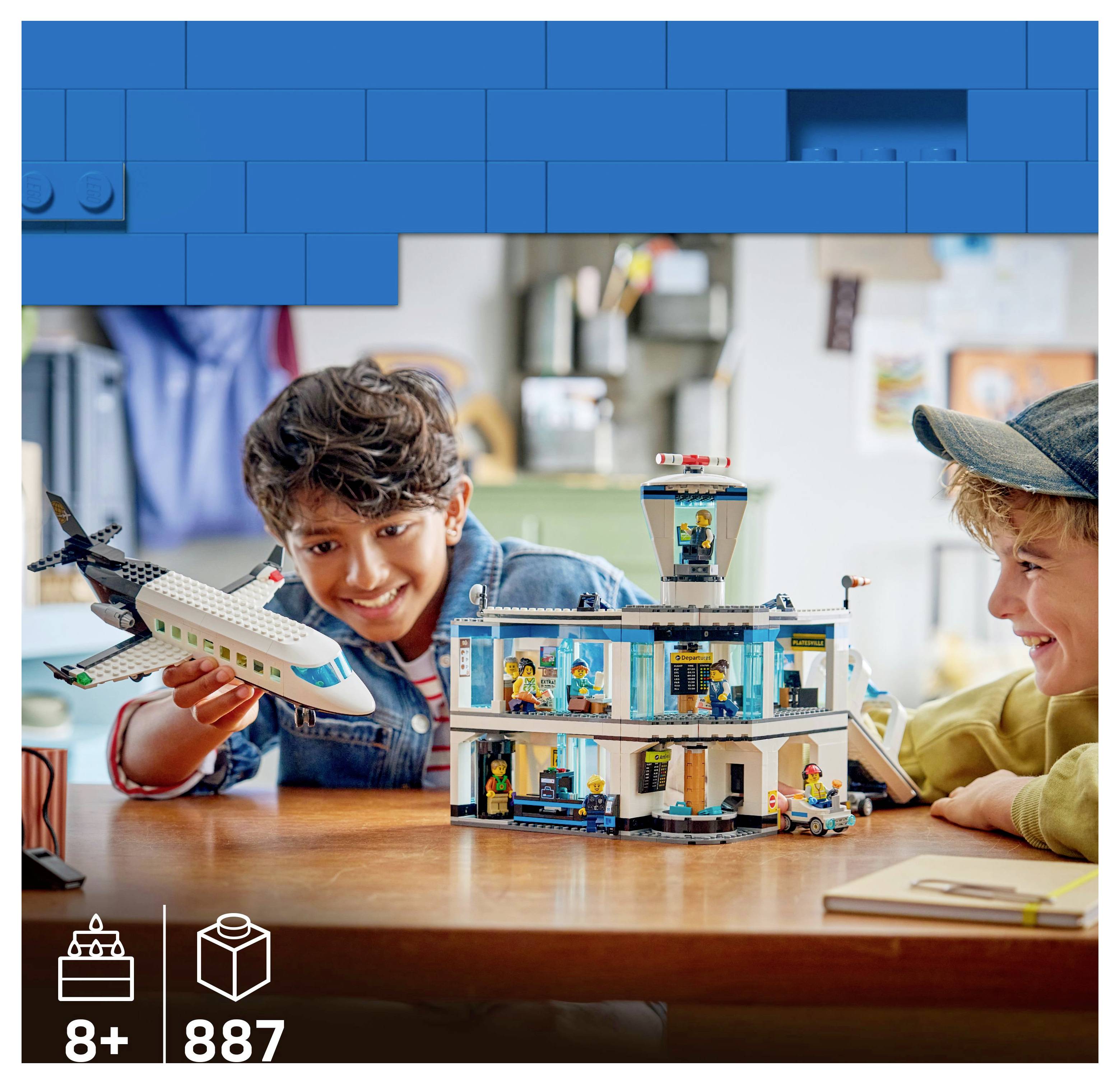 Két gyerek egy játék repülőtéri készlettel játszik, amely magában foglal egy repülőgépet és egy terminált. A csomagolás jelzi, hogy 8 éves kor felett ajánlott, és 887 darabból áll.