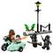 Egy Lego jelenet, amelyen egy motorkerékpár és egy oldalkocsi karakterei két köpönyeges alak elől menekülnek. A háttérben egy utcai lámpa és növények láthatók.