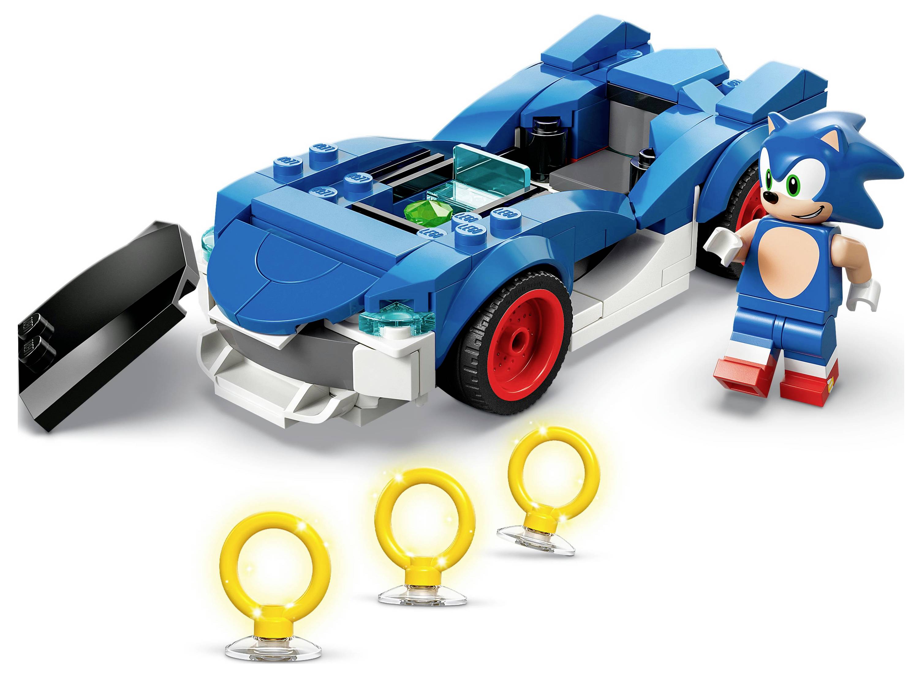 Játék épületkészlet, amely egy kék autót és egy figurát tartalmaz, előtte három sárga gyűrűvel. Az autó karcsú kialakítású.