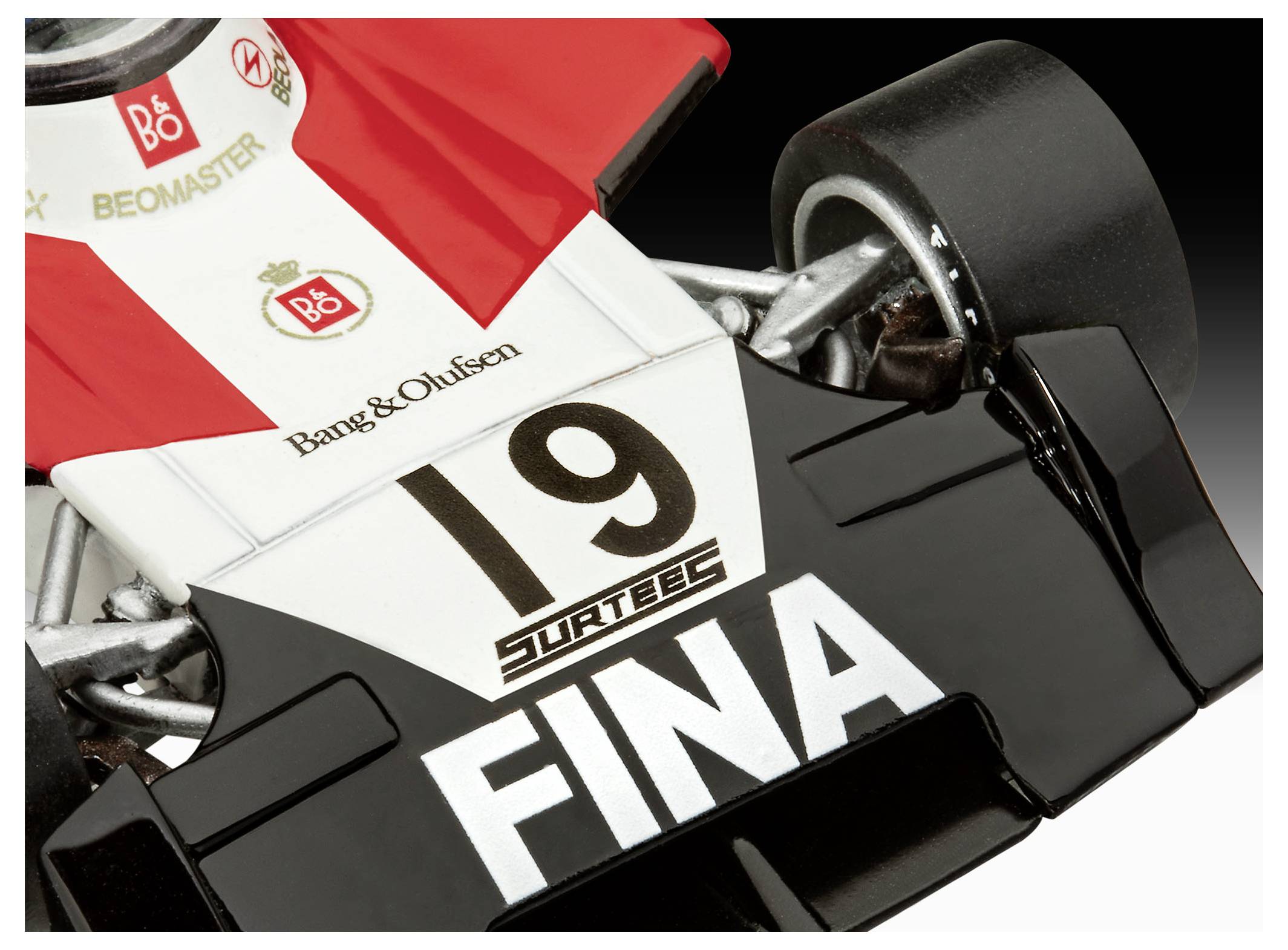 Egy piros-fehér vintage versenyautó modell közelképe, amelynek elejére nagy méretben a '19' és a 'FINA' felirat van felfestve.