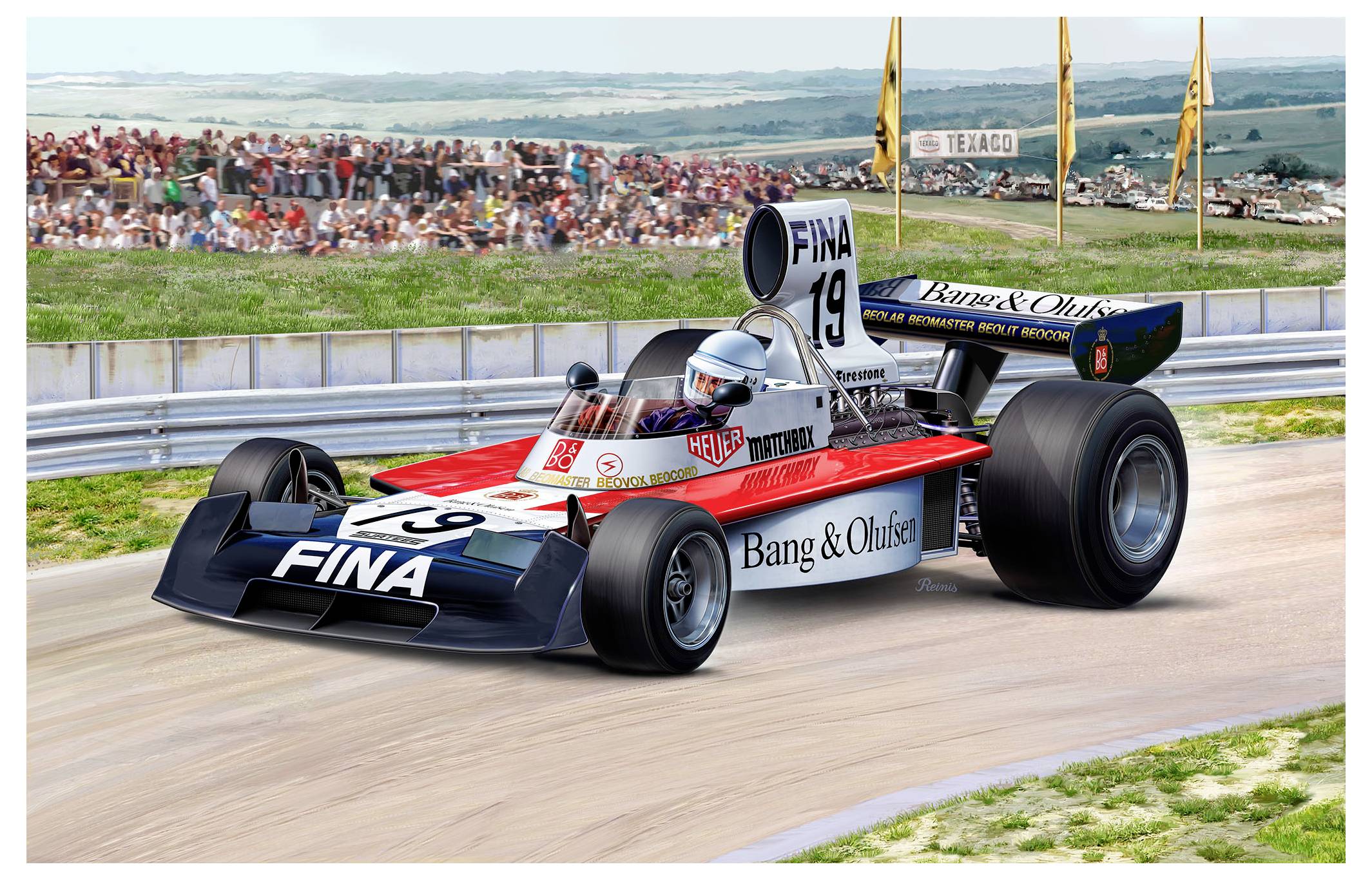 Egy veterán Formula 1-es autó száguldozik a versenypályán 'Fina' és 'Bang & Olufsen' márkák reklámfeliratával, egy nézelődő tömeg és távolban húzódó dombok által övezve.