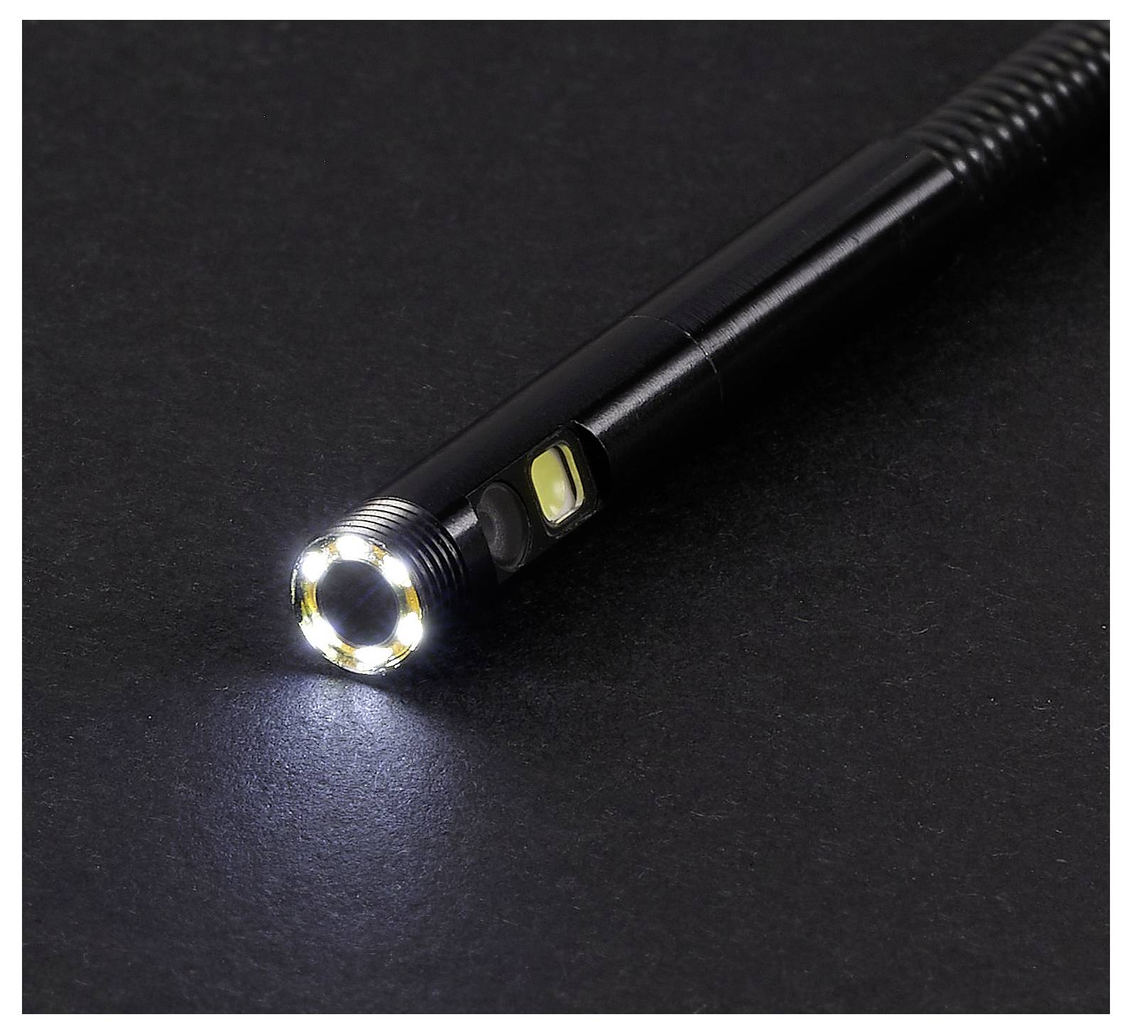 Fekete kézi LED-es zseblámpa egy sötét felületen, amely egy fényes kör alakú nyalábot sugároz.