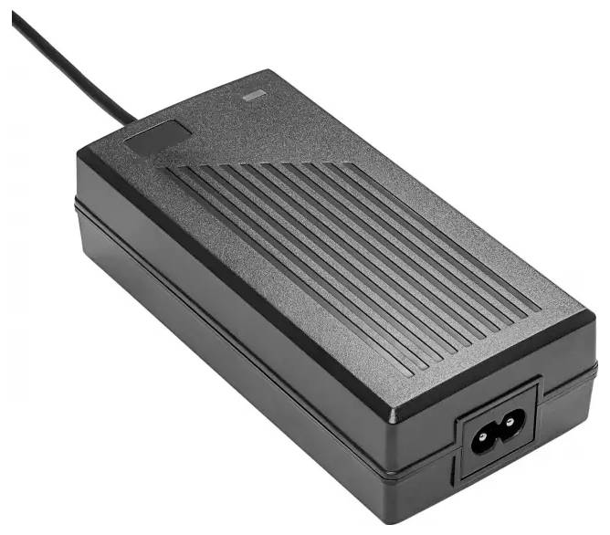 Egy fekete, téglalapú tápegység strukturált felülettel és hozzácsatlakoztatott tápkábellel, amelyet elektronikai eszközök áramellátásának biztosítására terveztek.