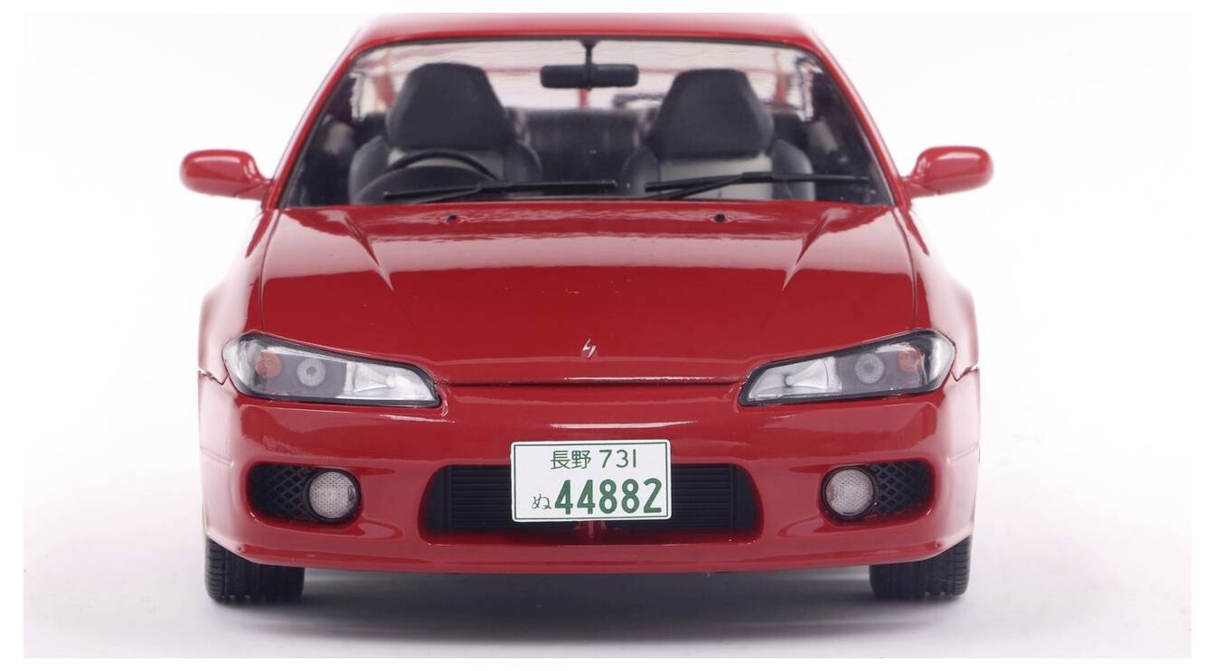 Egy piros sportautó modell látható elölnézetben, jól kivehető fényszórókkal és egy '73-44882' rendszámú rendszámtáblával.