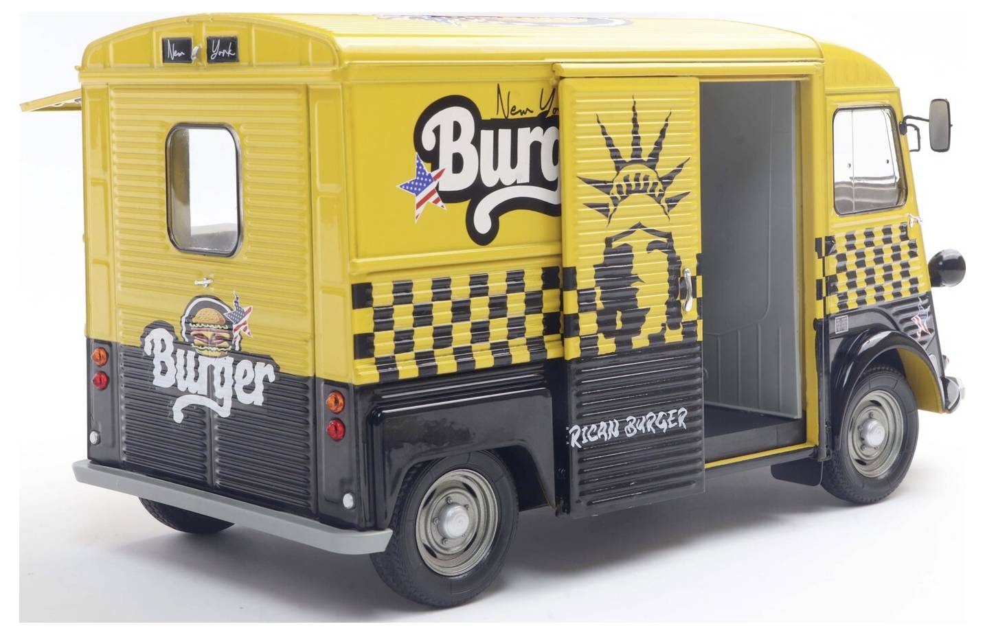 Sárga ételhordozó jármű, amelyen a 'New York Burger' felirat szerepel fekete-fehér kockás mintázattal és a Szabadság-szobor képével.