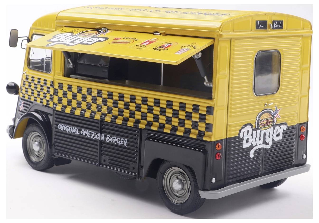 Egy sárga és fekete, vintage stílusú hamburger food truck, nyitott kiszolgálóablakkal és kockás dizájnnal, amelyen az 'Eredeti Mexikói Burger' felirat látható.
