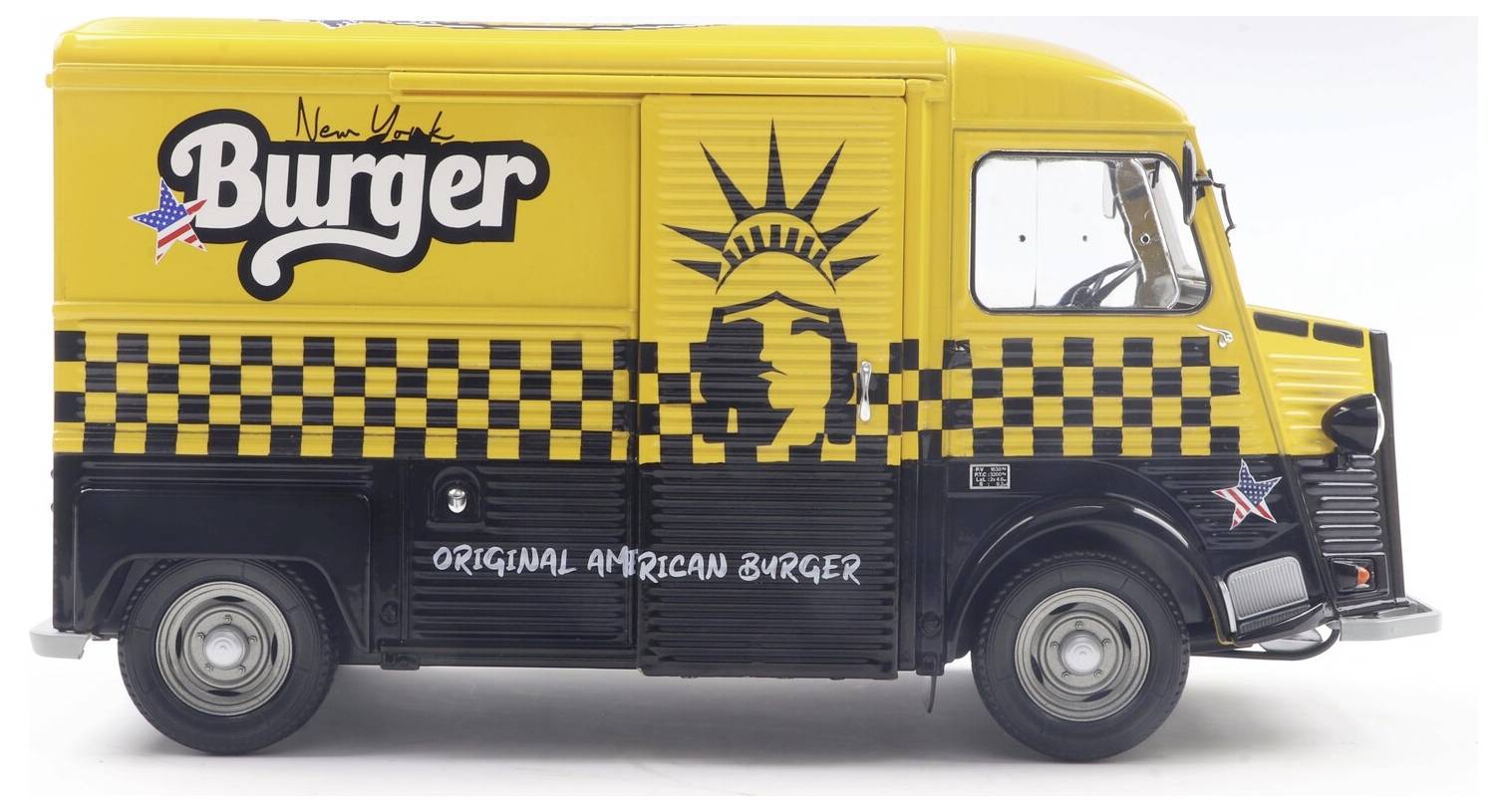 Egy sárga és fekete, kockás mintázattal és csillagokkal díszített food truck, rajta a 'New York Burger' felirattal és a Szabadság-szobor logóval.