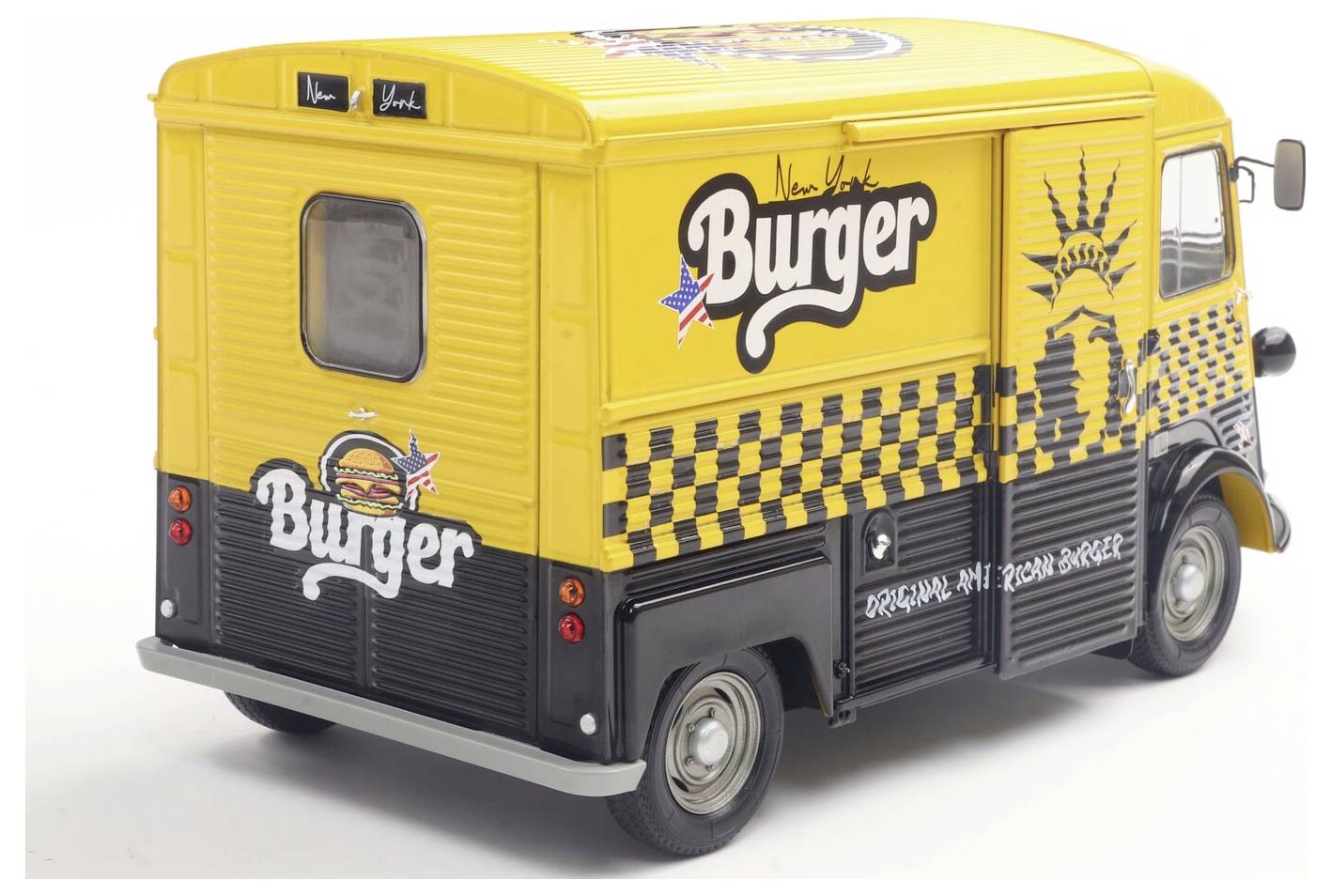 Egy sárga és fekete vintage étel-büfékocsi, amely a 'New York Burger' feliratot és a Szabadság-szobor képét viseli, és hamburgereket népszerűsít.