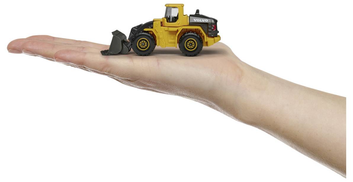 Egy kisméretű sárga játék buldózer, amelynek oldalán 'VOLVO' felirat látható, egy kiterjesztett emberi kézen nyugszik, kiemelve a játékszer apró méretét.