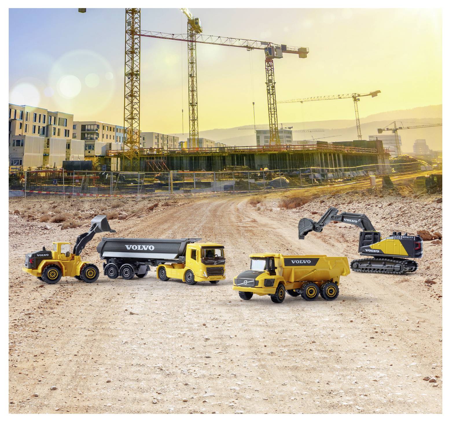 Épülőfélben lévő terület piszkos úttal, épülő épületek által szegélyezve. Volvo márkajelzésű munkagépek, köztük teherautók és egy kotró láthatók az előtérben. Daruk emelkednek a háttérben, naplementés égbolt előtt.