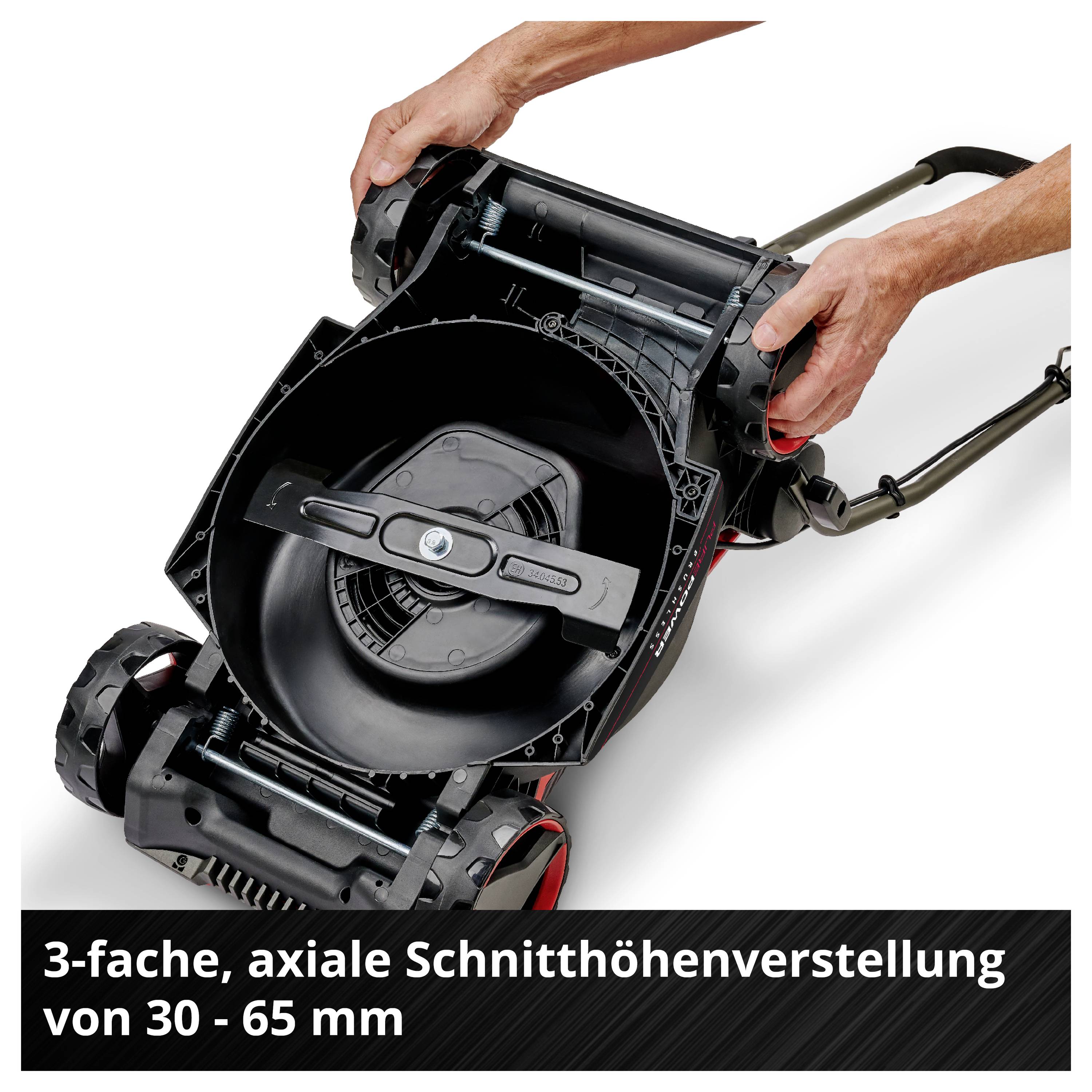 Fűnyíró háromszoros, axiális vágásmagasság-beállítással 30-65 mm között, egy személy által bemutatva, aki éppen használja a magasságállítást.
