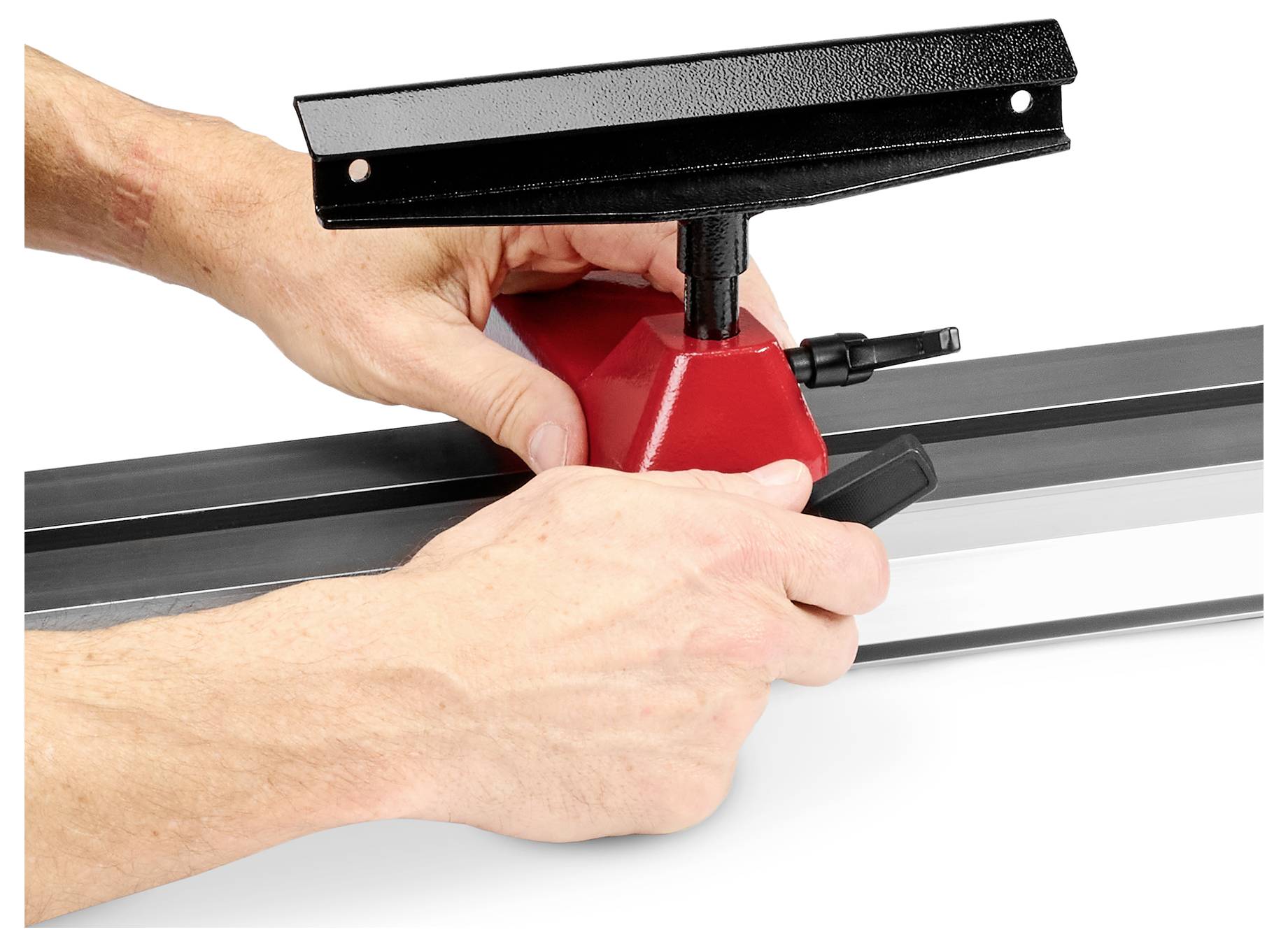 Egy piros szerszámot fekete és szürke sínre igazító kezek, valószínűleg mérő- vagy építőipari felszerelés részeként.