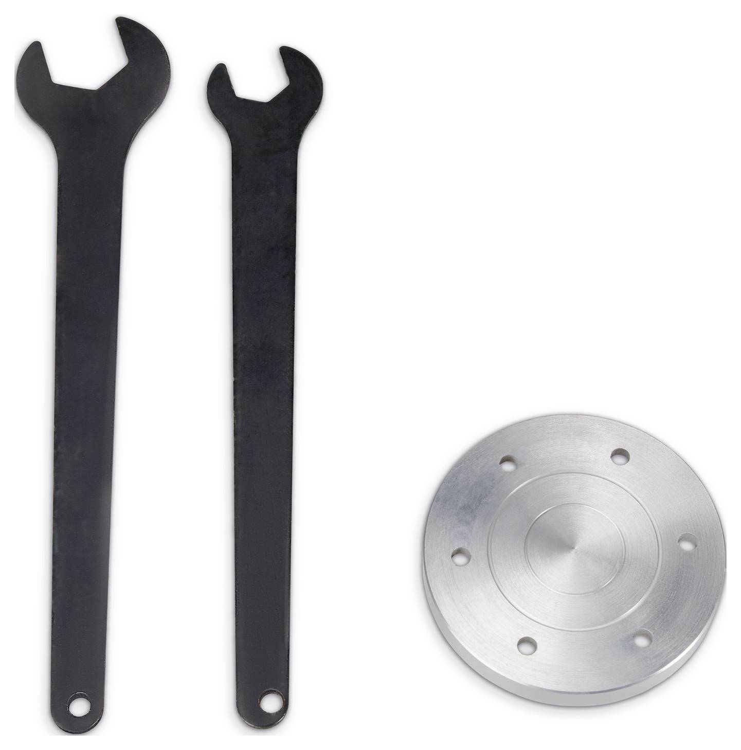Két fekete csavarkulcs és egy kerek ezüst fémtárgy oldalsó lyukakkal, fehér háttér előtt.