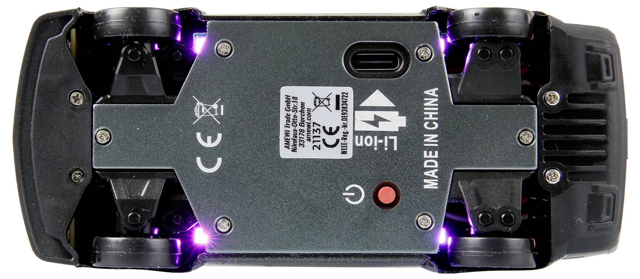 Egy játékautó alsó oldala, amelyen láthatók a kerekek, csavarok, egy USB-port és egy kapcsoló; rajta a 'Kínában készült' felirat.