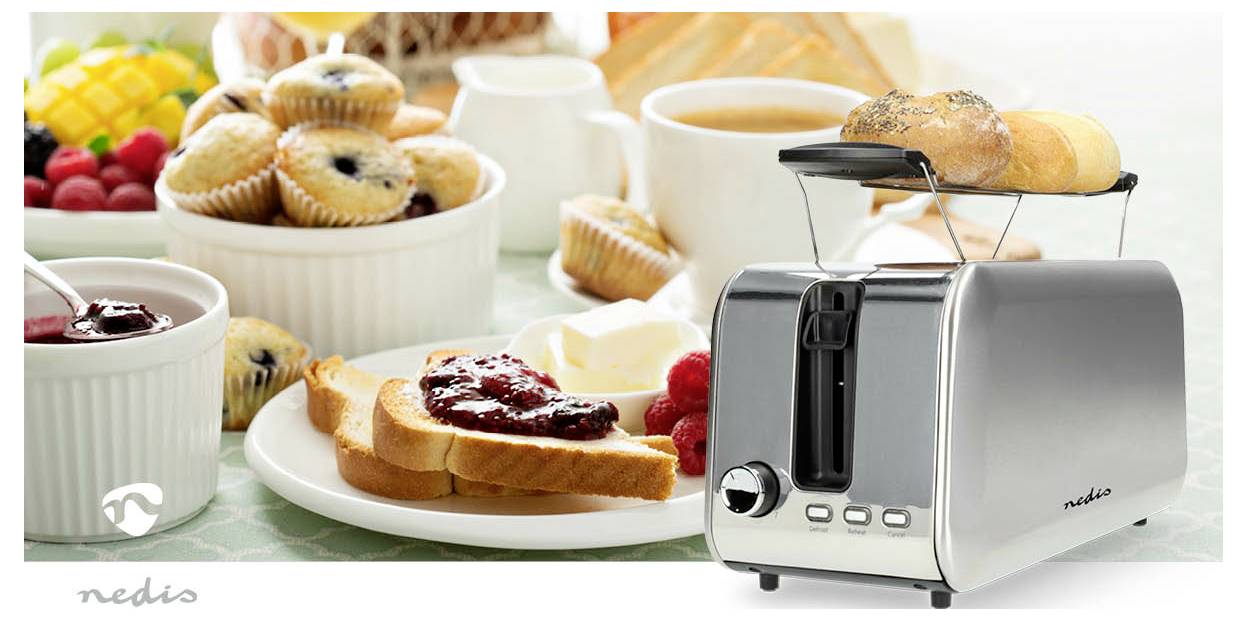 Egy modern kenyérpirító kenyérszeletekkel az előtérben. A háttérben egy reggeli terítés látható muffinokkal, pirítóssal és kávéval.