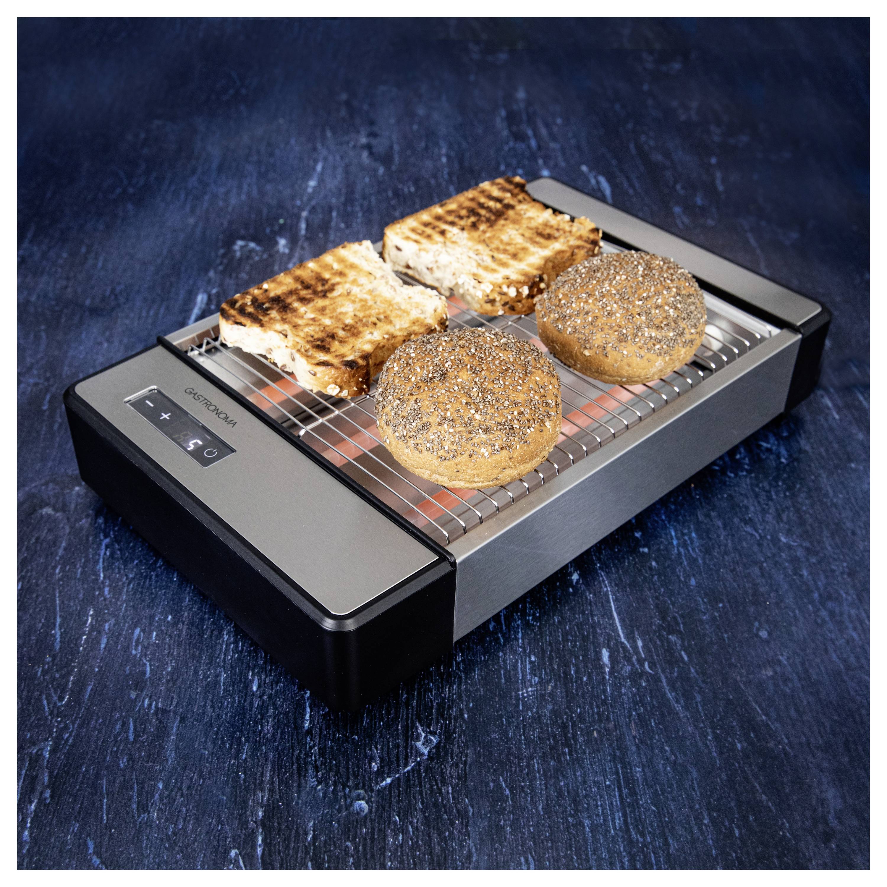 Négy szelet kissé megpirult kenyér, ebből kettő mákos, egy modern, áramvonalas, nyitott rácsú rozsdamentes acél kenyérpirítón.
