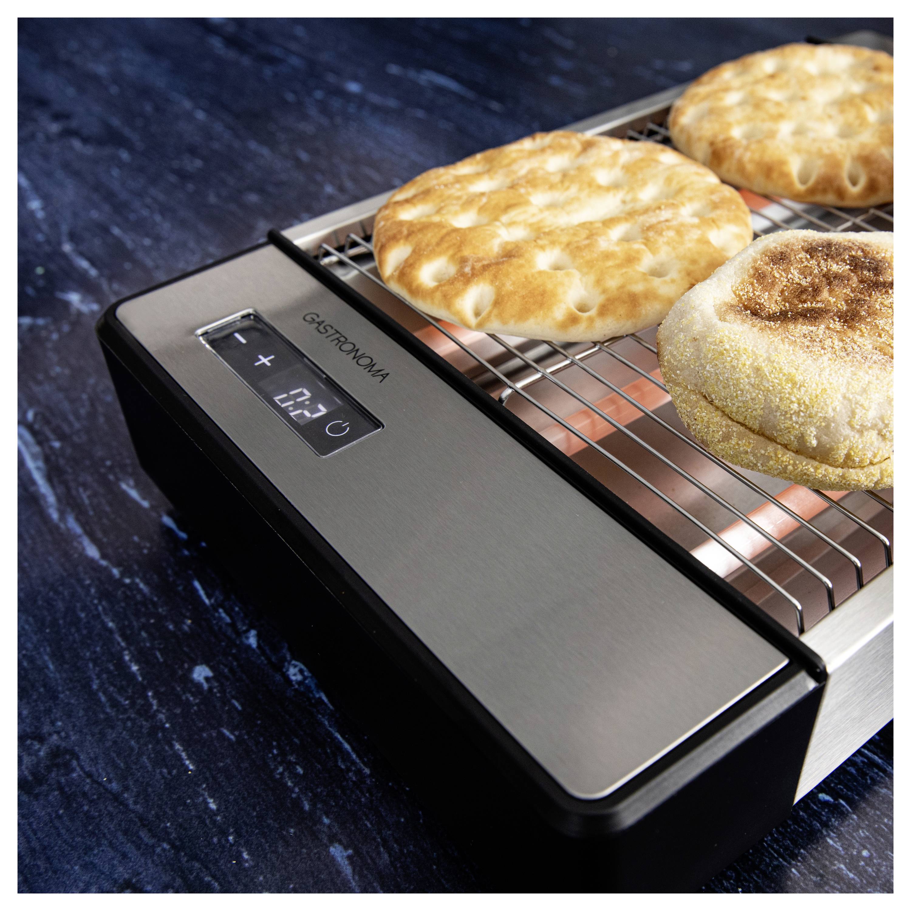 Egy munkapultra helyezett sütő, amint kenyérlángost süt barnás felső réteggel. A kijelzőn hőmérséklet látható, jelezve az aktív sütési folyamatot.