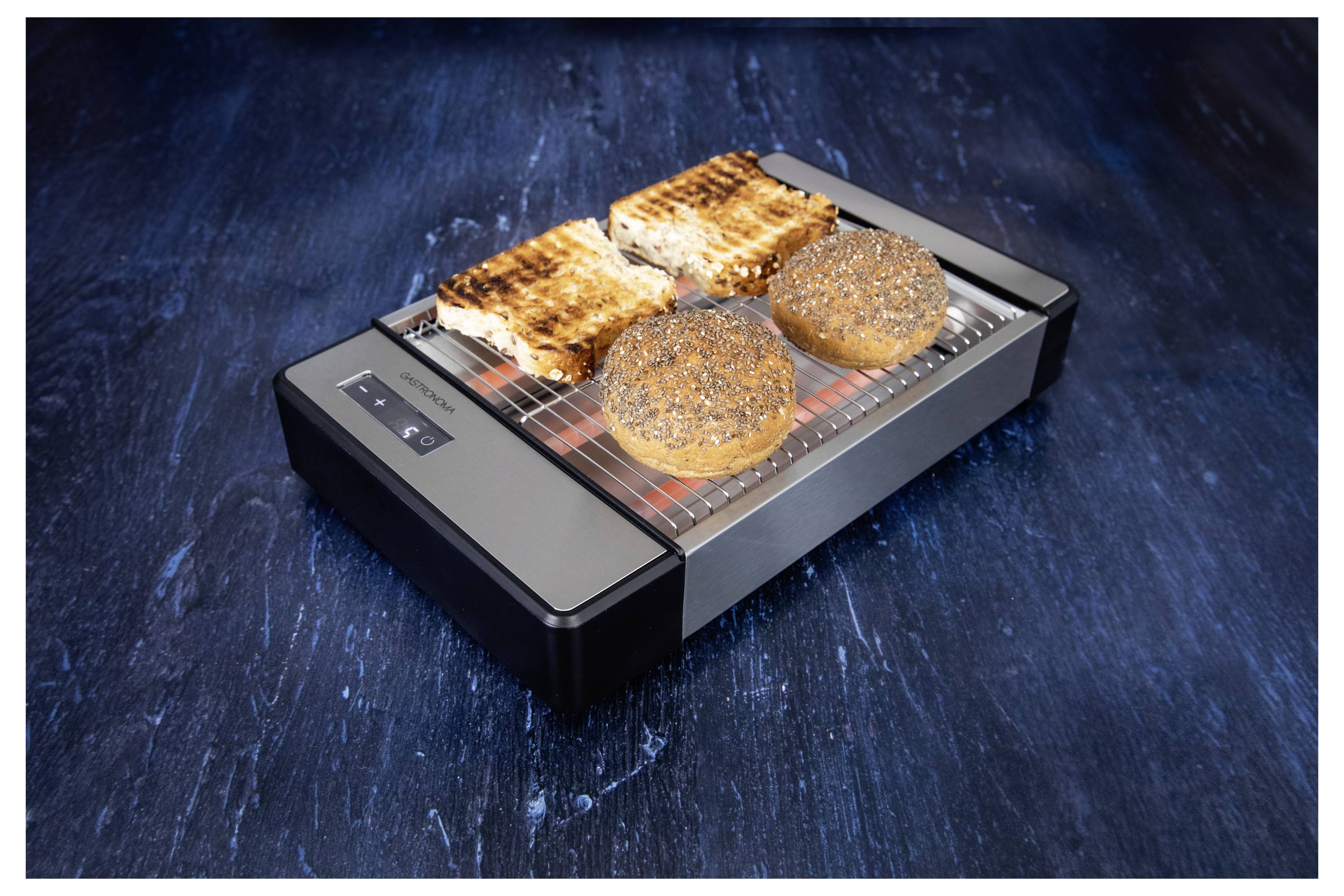 Egy felülnézeti kép egy kenyérpirítóról, amelyen két pirított szendvicsszeletet és két mákos tetejű zsemlét sötétkék felületen látni.