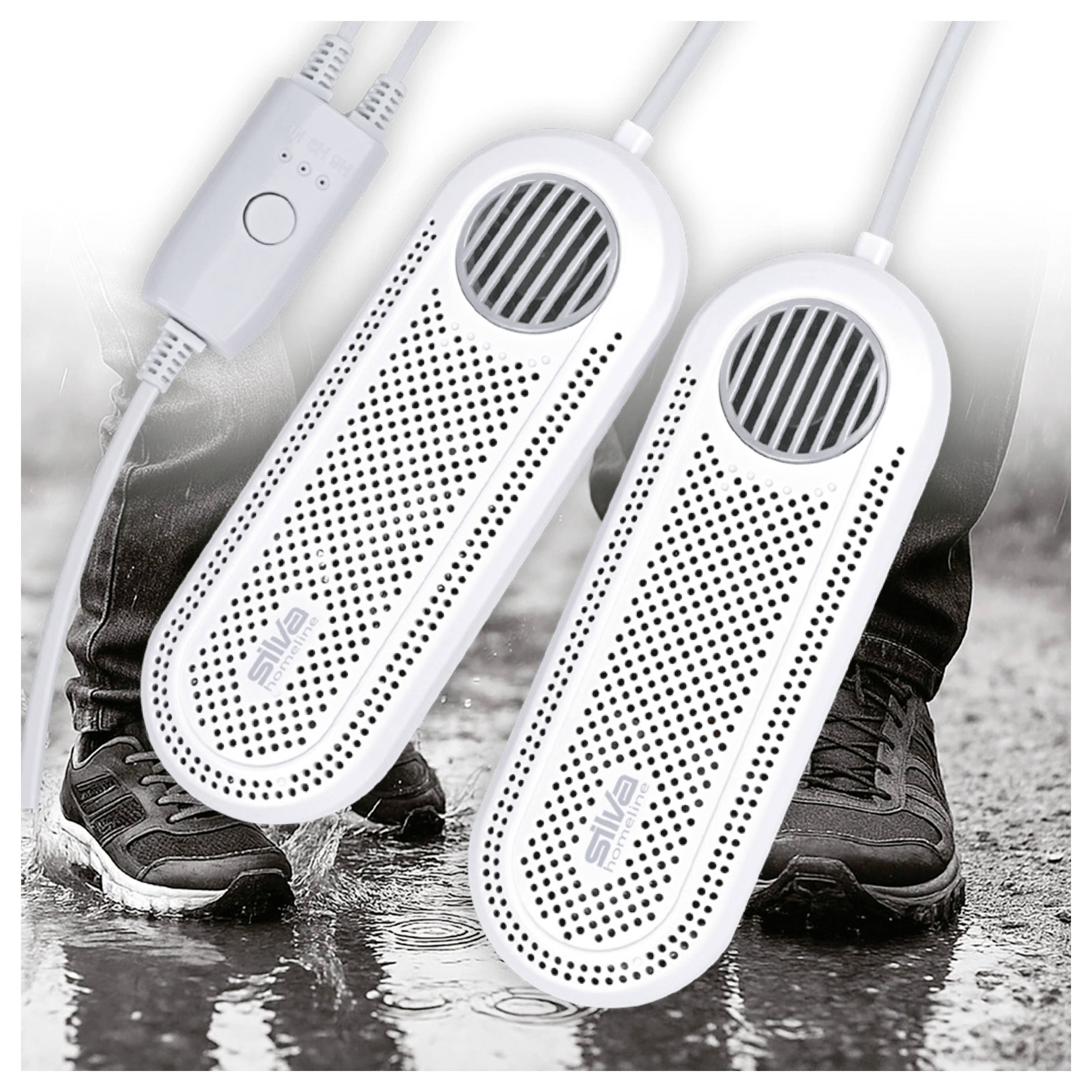 'Két fehér cipőszárító, mindegyik szellőzőnyílásokkal és zsinórokkal, nedves felületen elhelyezve. Fekete nadrágos és cipős lábak láthatók a háttérben.'