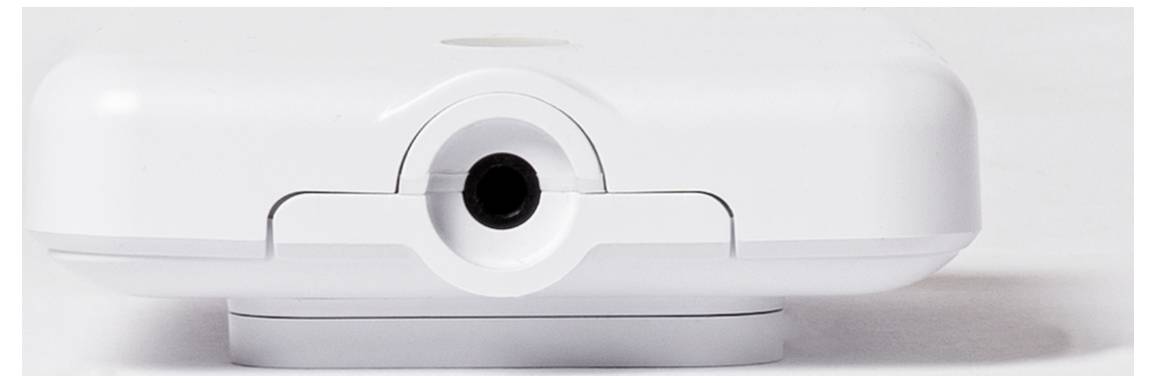 Egy fehér elektronikai eszköz fekete, kerek porttal az elején, fehér háttér előtt.