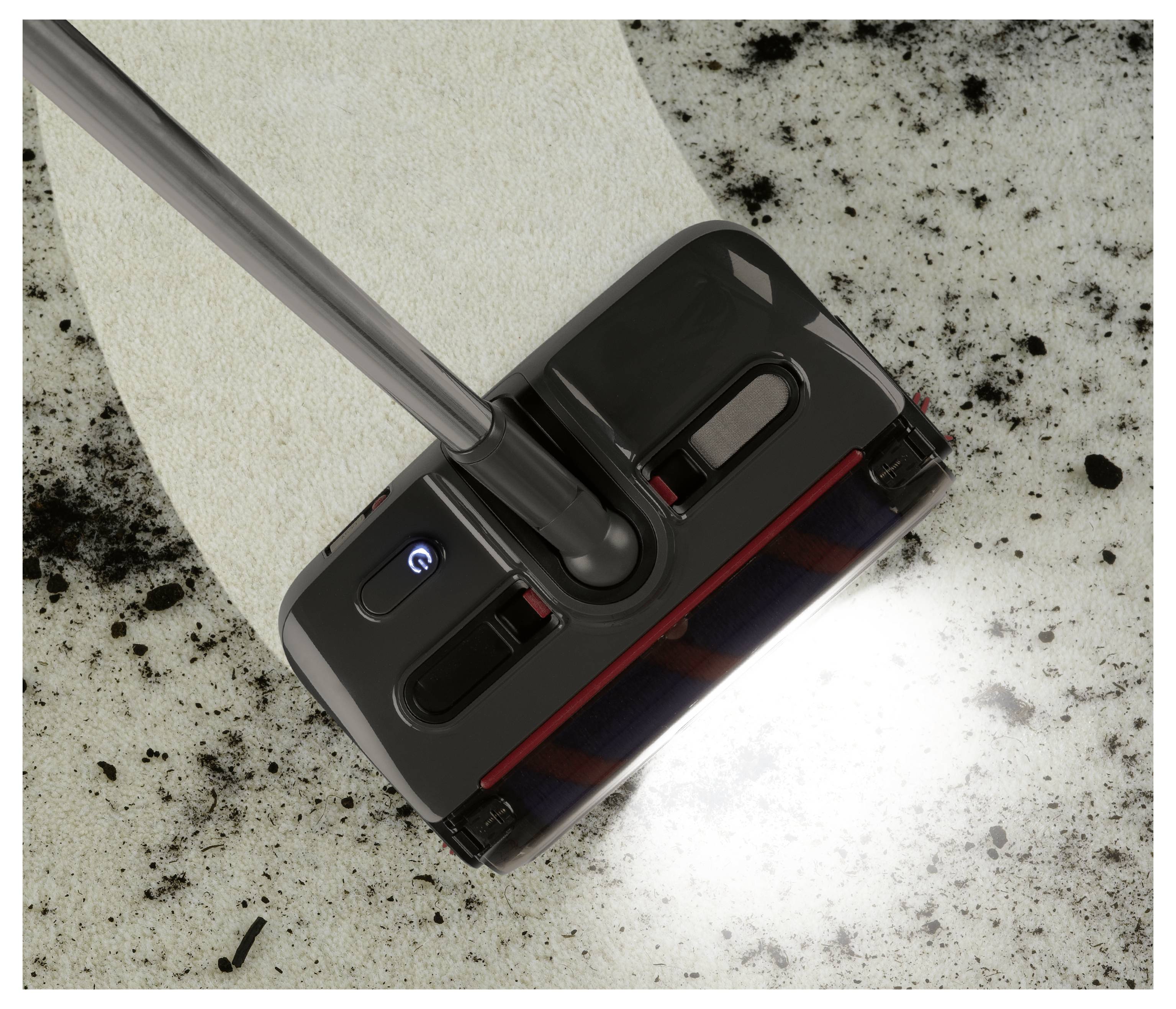 Egy tisztítóeszköz megdörzsöli a szőnyeget, eltávolítva a szennyeződéseket és a foltokat. A háttér jól látható kontrasztot mutat a tisztított és szennyezett területek között.