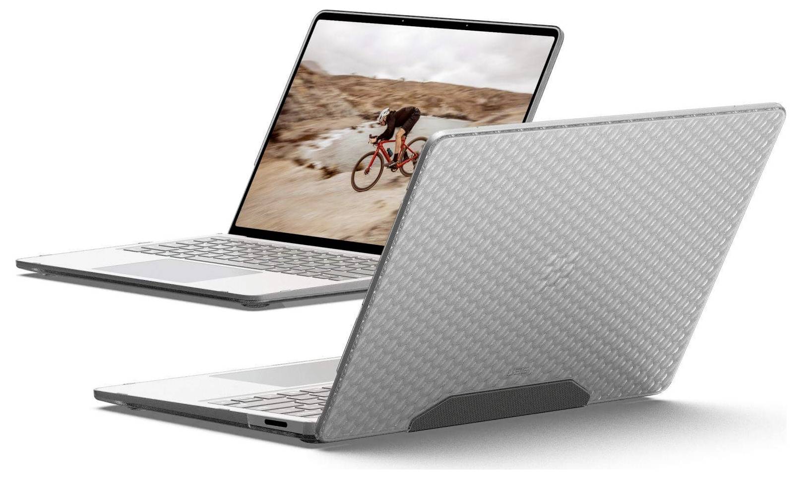 Két laptop: az egyik egy személyt mutat kerékpározni a sivatagban, a másik texturált szürke borítással, amely a kalandot és az időtállóságot szimbolizálja.