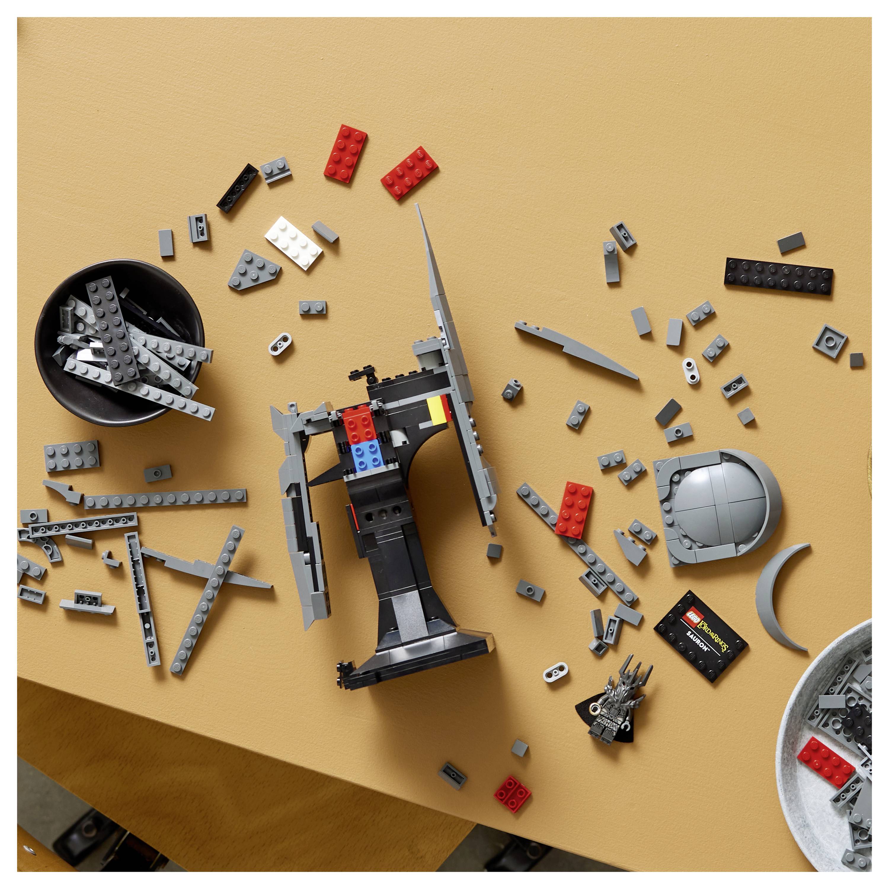 Szétszórt Lego kockák az asztalon, részben összerakott egy űrhajóra vagy űrállomásra hasonlító modellé.