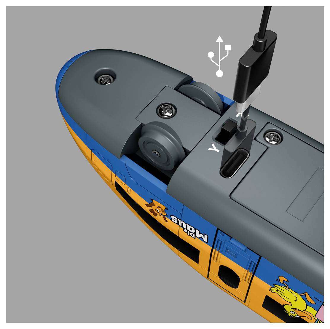 Egy játékvonatok töltőportjának közeli képe csatlakoztatott kábellel. A vonat kék és narancs színű, rajzfilmes grafikákkal díszített.