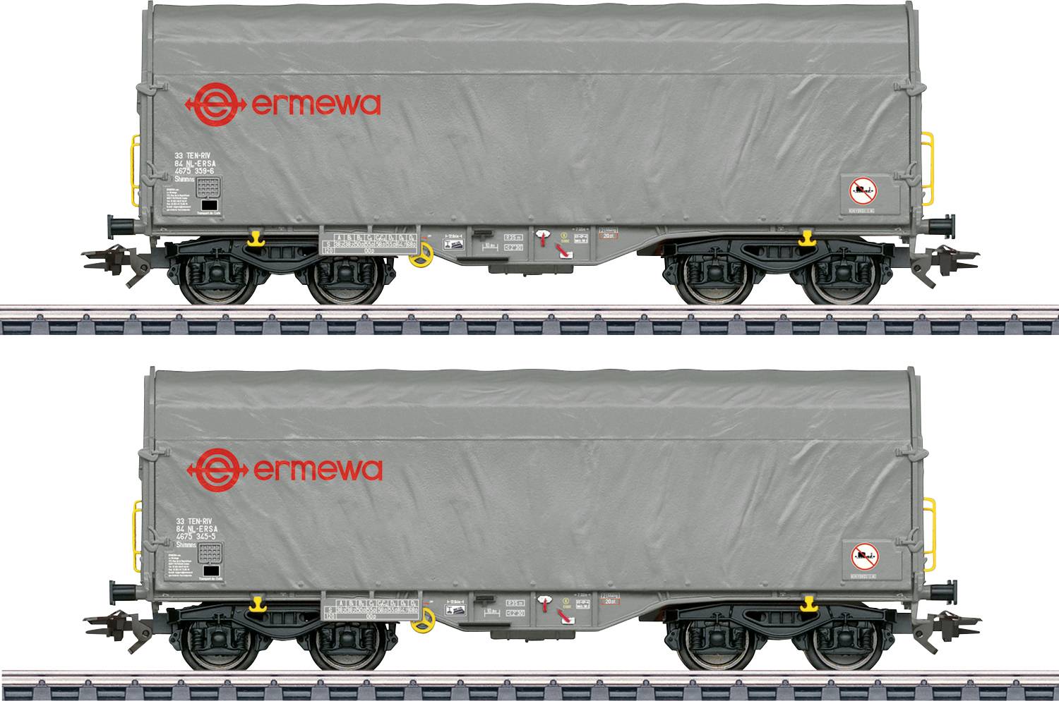 Egy szürke tehergépkocsi vasúti vagony, amelynek oldala piros "ermewa" logóval rendelkezik, vasúti síneken parkolt. A vagony figyelmeztetési és biztonsági címkéket tartalmaz.