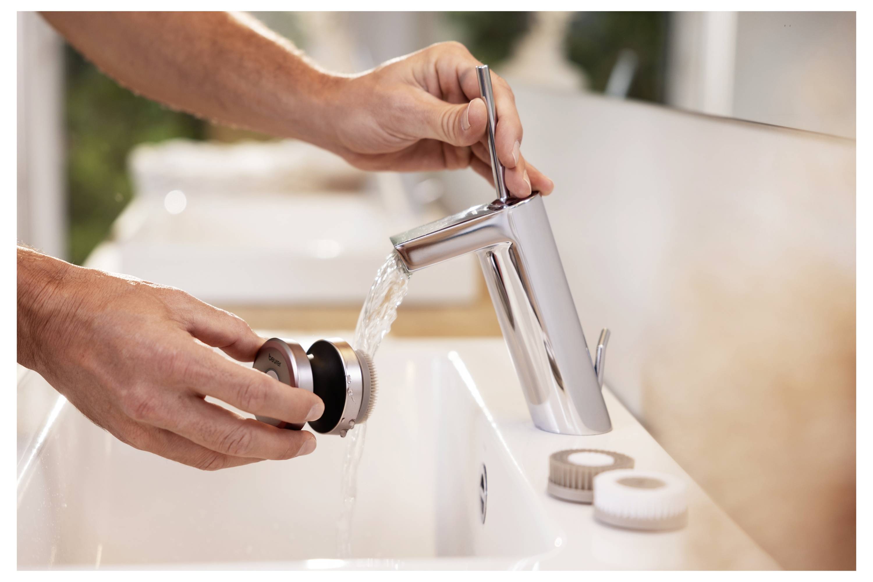 Egy személy egy fürdőszobai mosdó lefolyóját tisztítja meg egy modern krómcsap alatt folyó vízzel, amely karbantartást vagy tisztítást sugall.