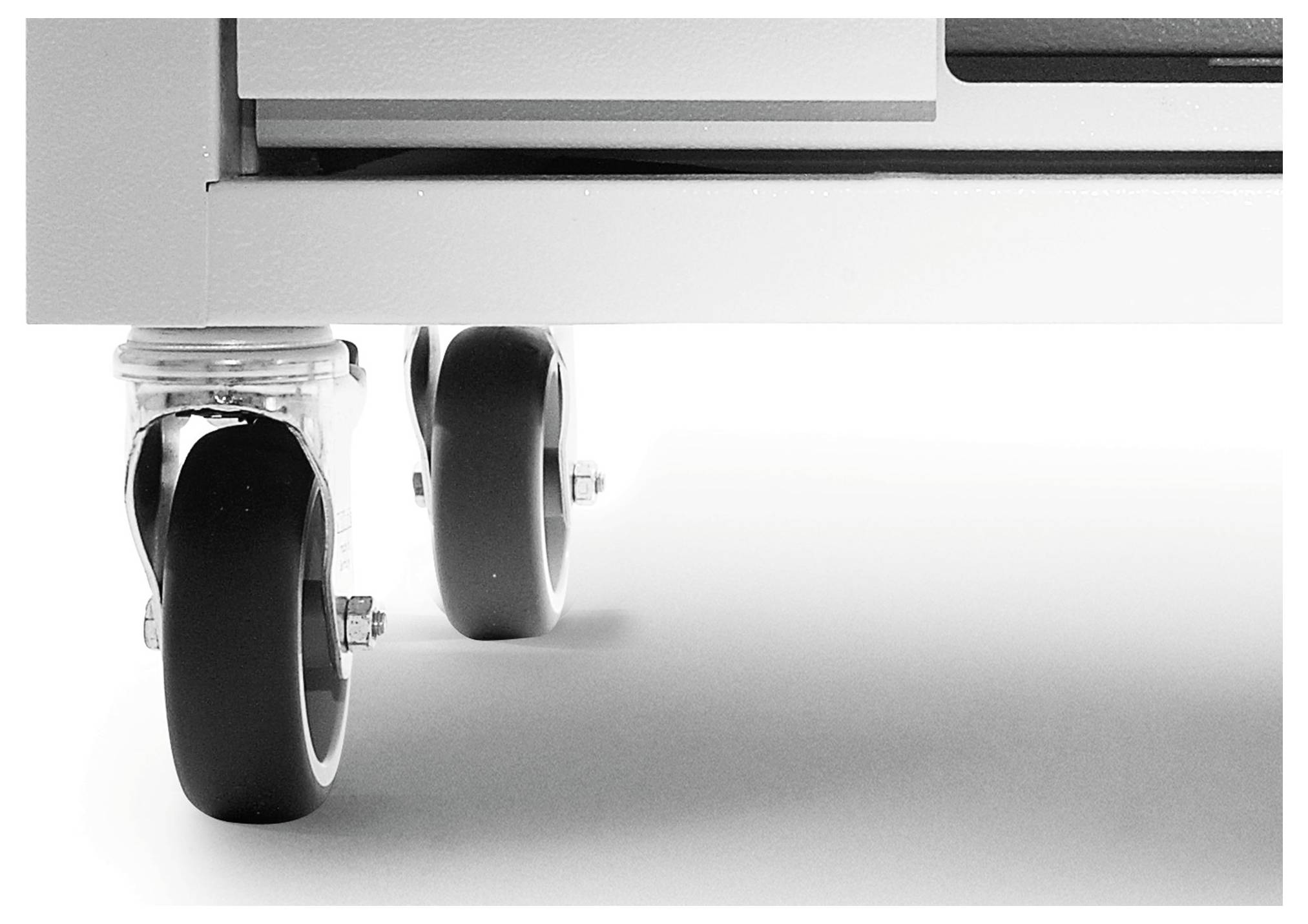 Két fekete görgő közelképe, amely egy bútor aljához van rögzítve fehér háttér előtt.