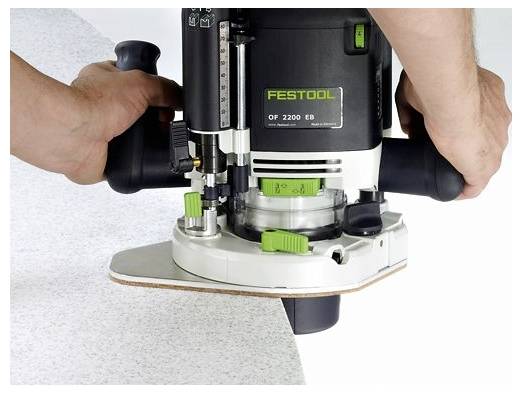 A kezek egy Festool útmaróját vezetnek egy fehér fa felület széle mentén, pontosan formázva azt.