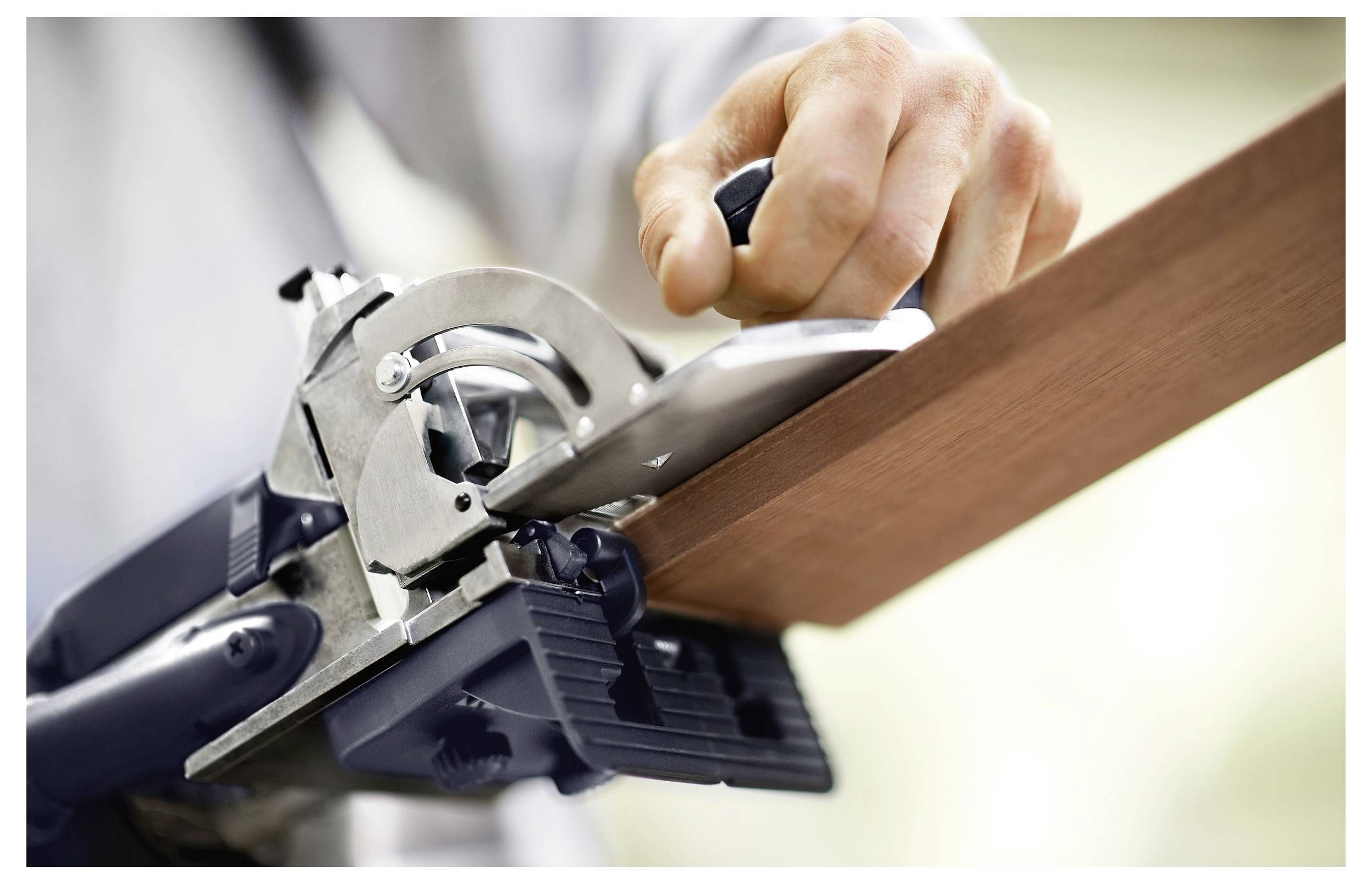 Egy elmosódott kép, amely egy fehér, ívelt felület egy részét mutatja, egy homályos tárggyal mögötte, amely valószínűleg egy szerszám, absztrakt jeleneteket hozva létre.