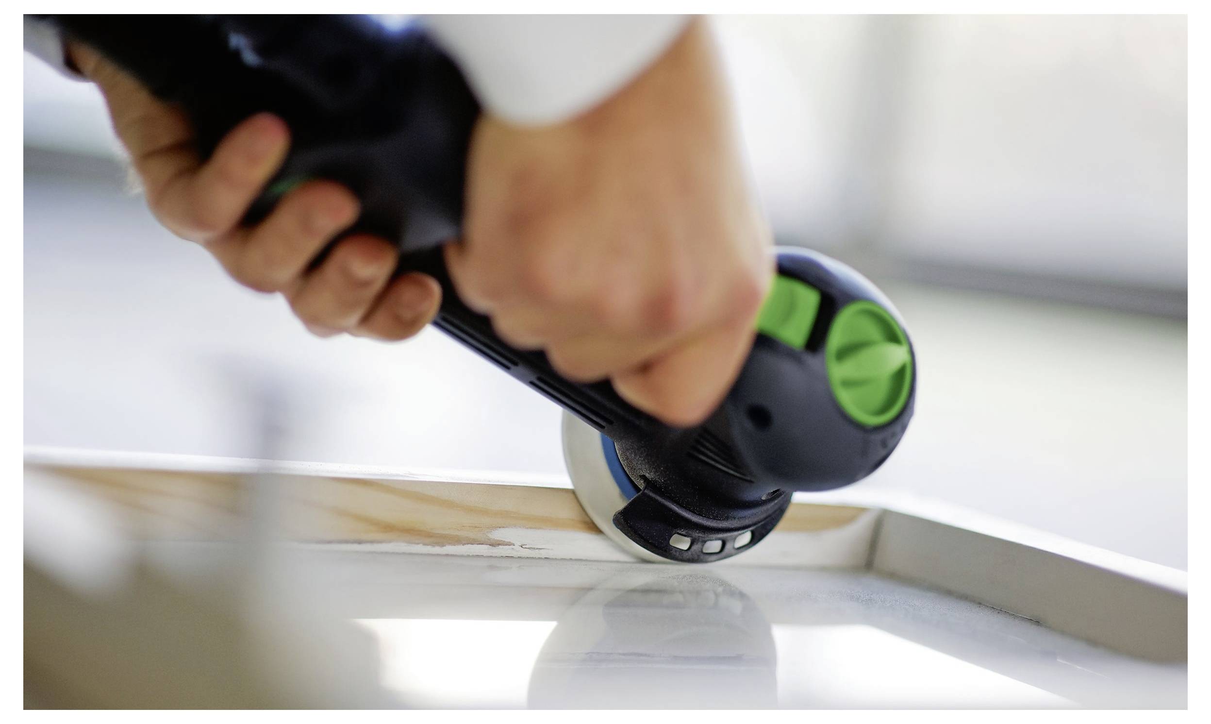Egy körpályás pályavágó fűrész fa vágásához, amely „Festool" márkázással látható. A fűrész egy asztalon helyezkedik el, precíz vágásra készen.