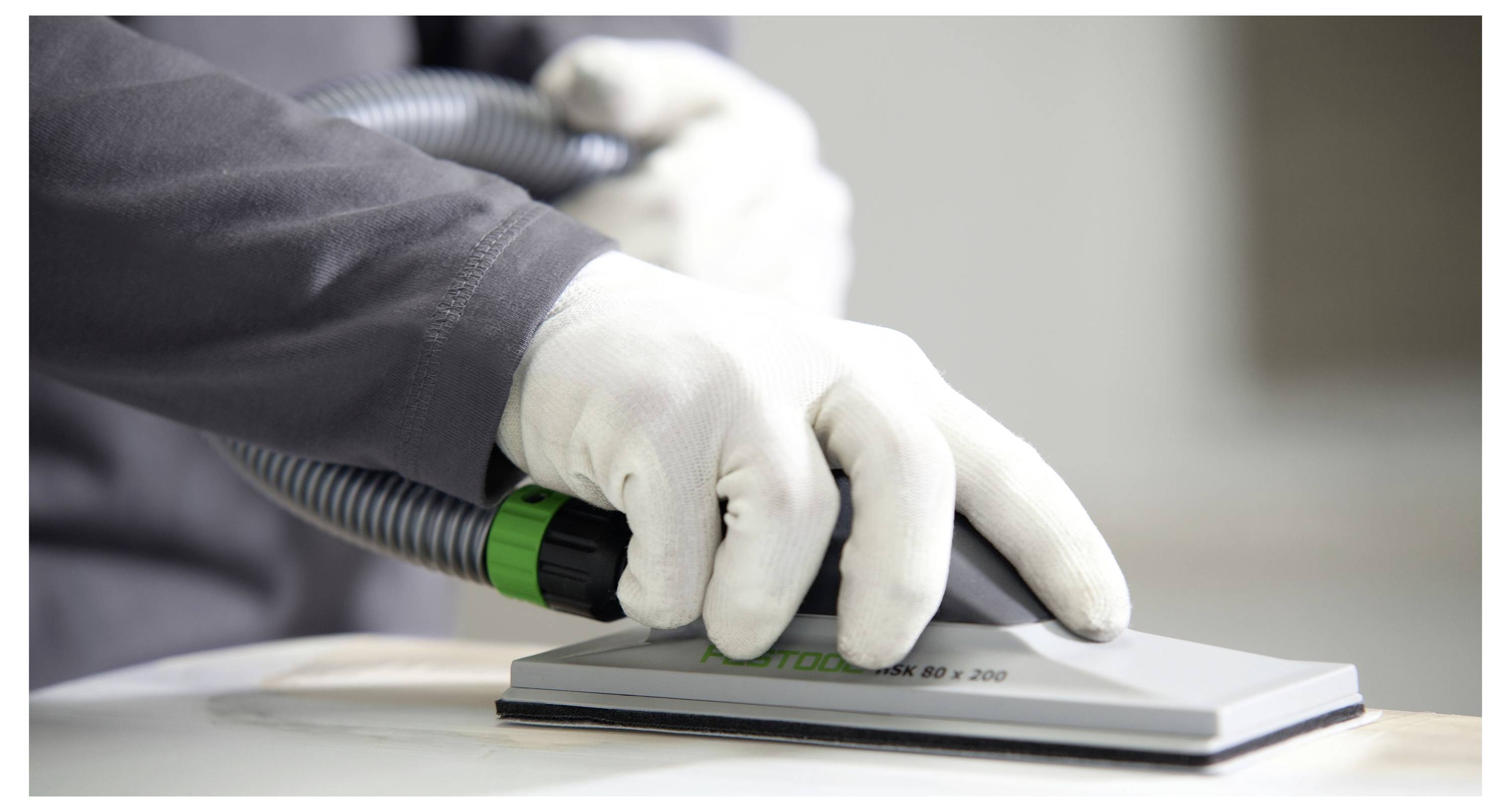'Fehér kesztyűs kezek közelképe, akik vákuum csiszológépet használnak egy fa felületre, a precizitásra és a sima felületmegmunkálásra összpontosítva.'