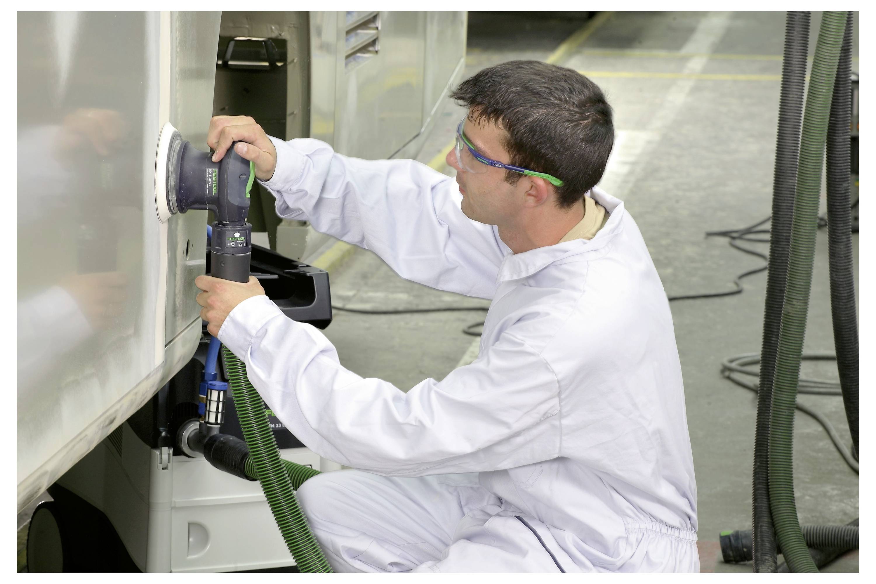 Egy személy két fa rudat tart, egy kötési technikát demonstrál, ahol egy csap egy lyukba illeszkedik, összehangolyozva az elemeket.