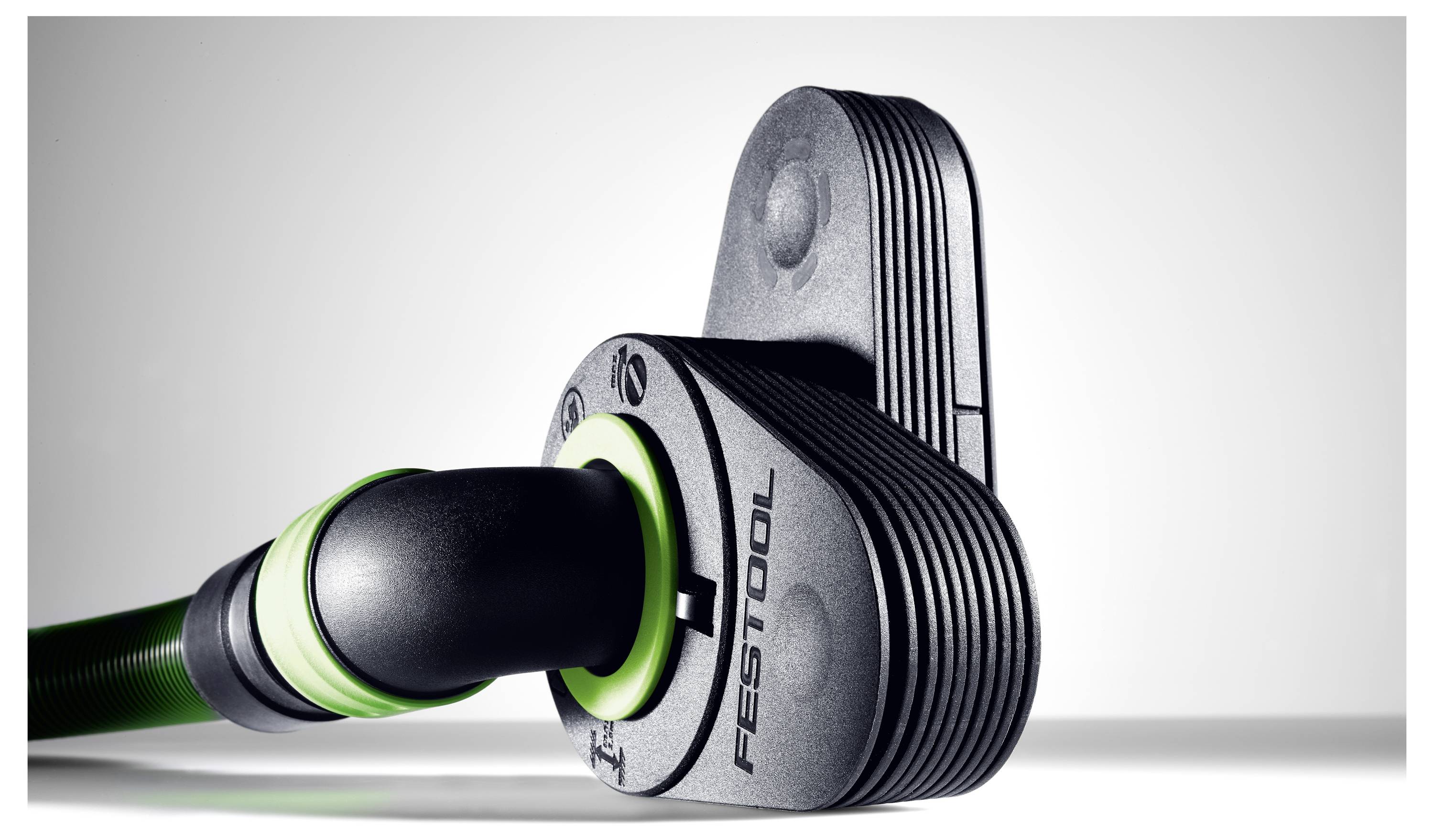 Egy Festool szerszámkiegészítés közeli képe fekete felülettel és zöld kiemelésekkel, amelyen látható a márka logója és a dizájn részletes textúrája.